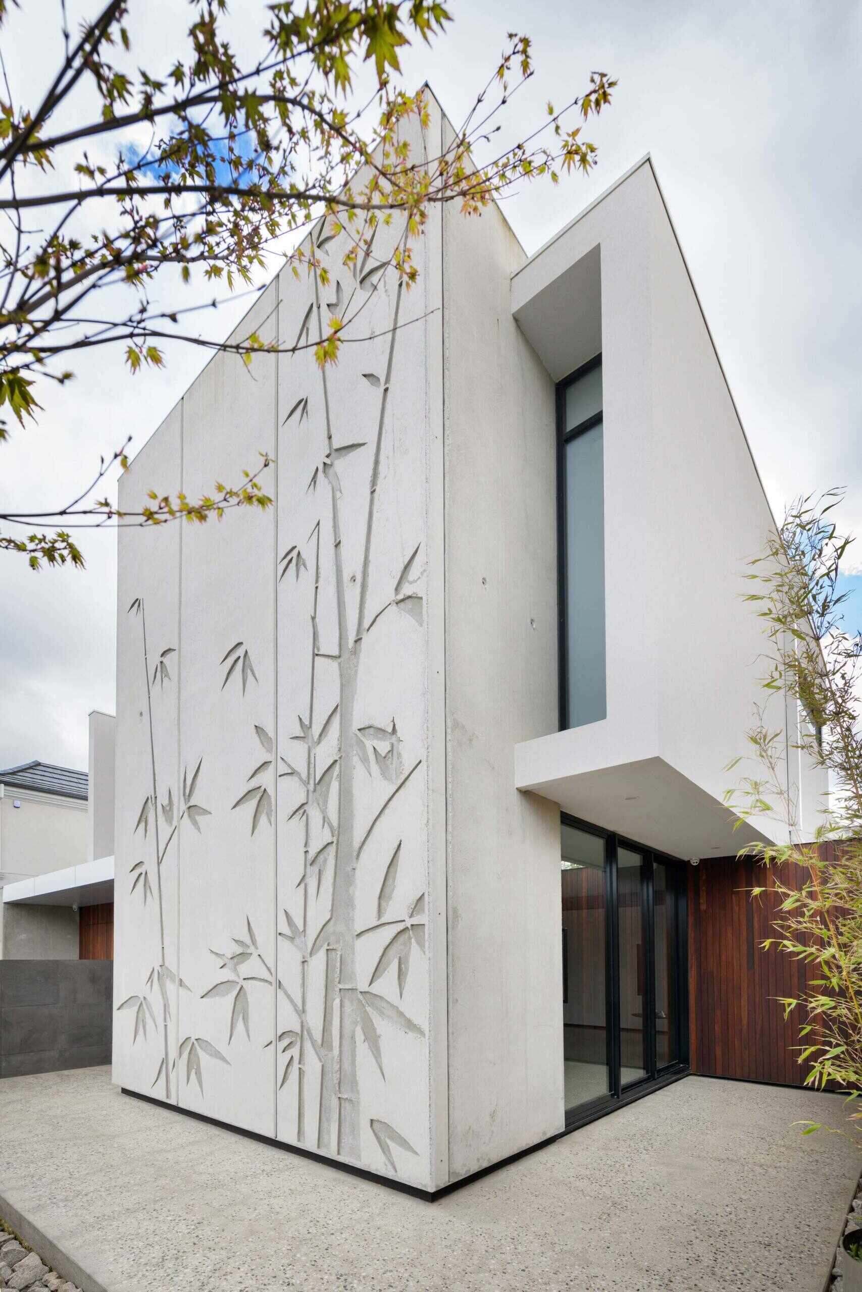 Tilt-up concrete panels with bamboo reliefs give this home a sculptural edge. The combination of raw concrete and natural texture strikes a balance between industrial and organic design.
