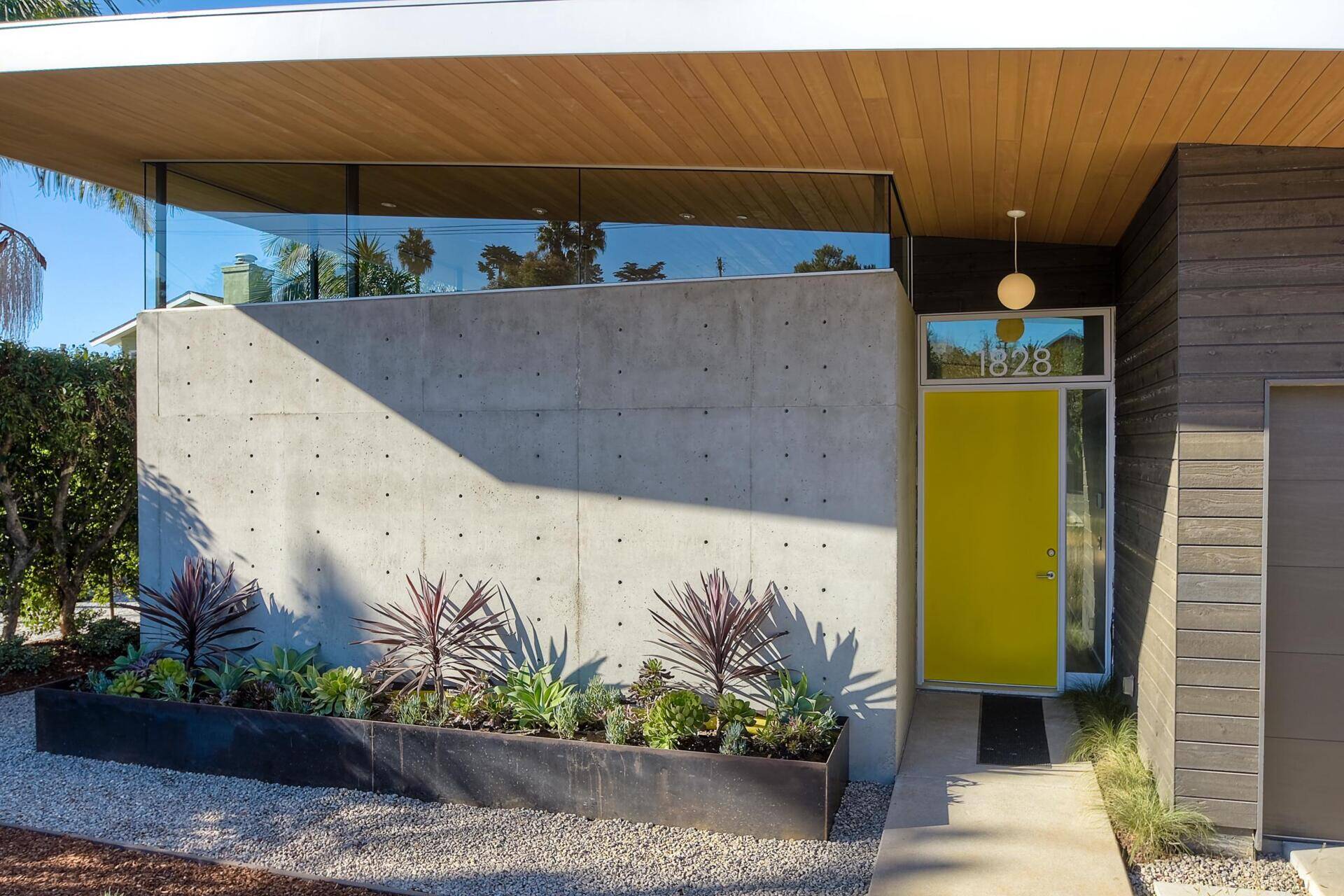 A bright yellow front door and angular roofline make this California home stand out from the street.