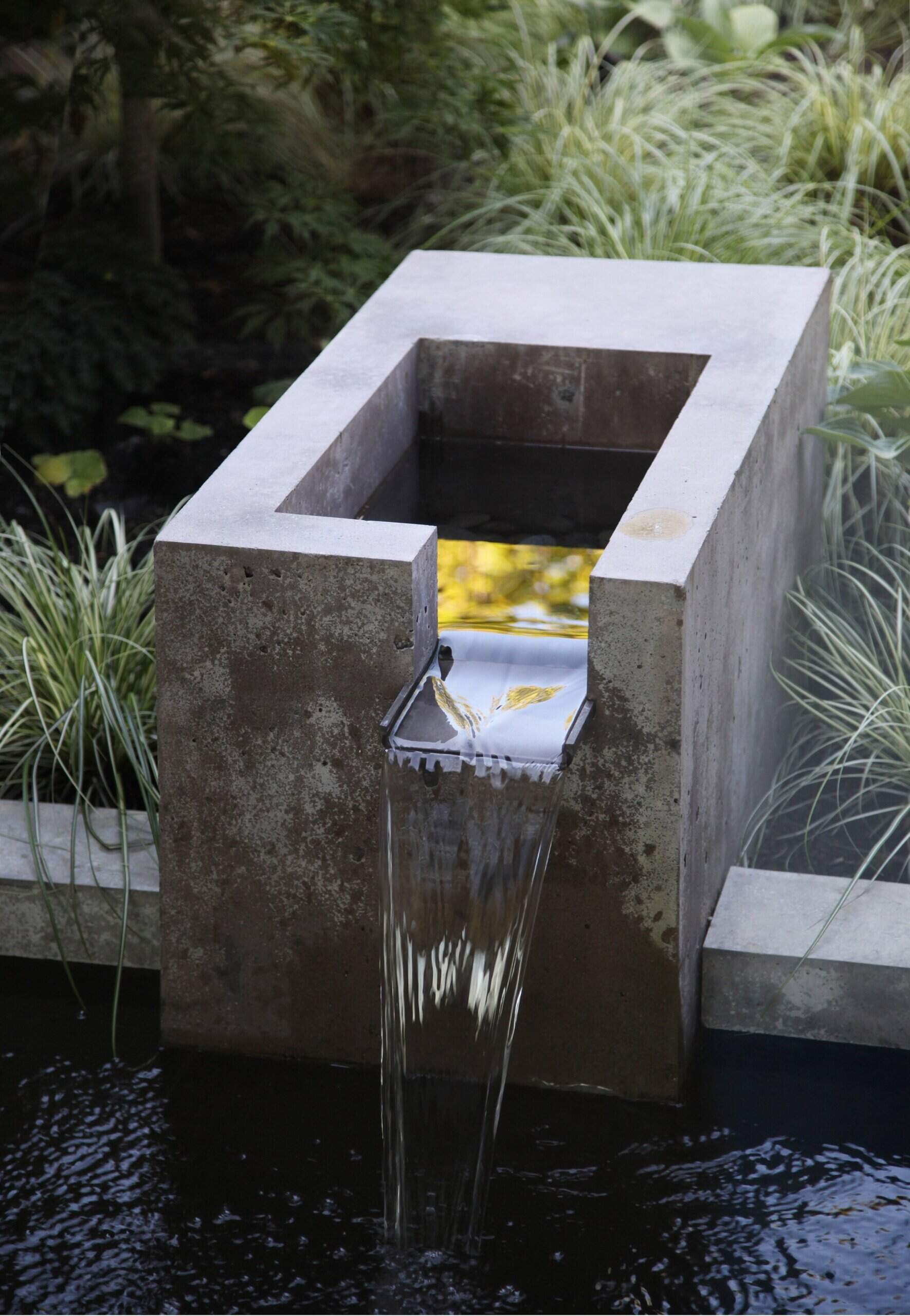 A lush courtyard with a concrete water feature connects every room to nature, serving as the peaceful heart of this renovated Laurelhurst home.