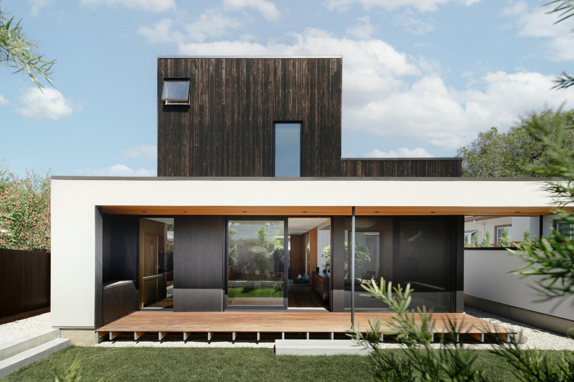A modern home with a deck at the rear of the home.