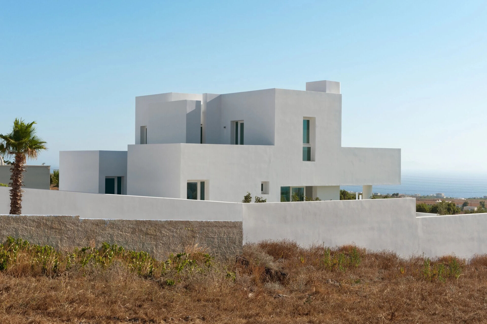 A striking example of modern Greek island design, this Santorini summer house by Kapsimalis Architects reinterprets traditional cubist architecture with clean lines, open volumes, and a serene palette of white and grey.
