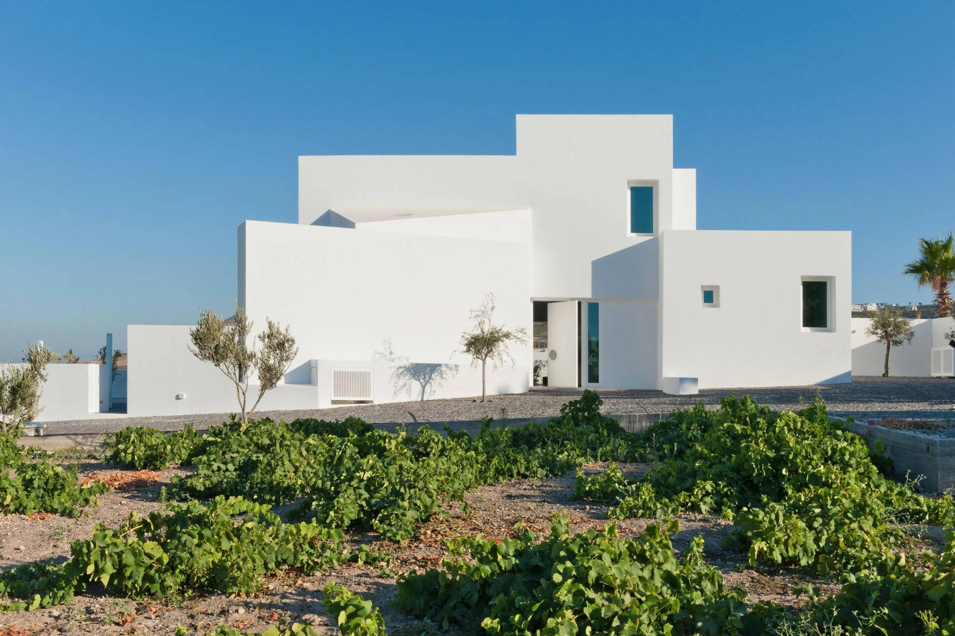 A striking example of modern Greek island design, this Santorini summer house by Kapsimalis Architects reinterprets traditional cubist architecture with clean lines, open volumes, and a serene palette of white and grey.