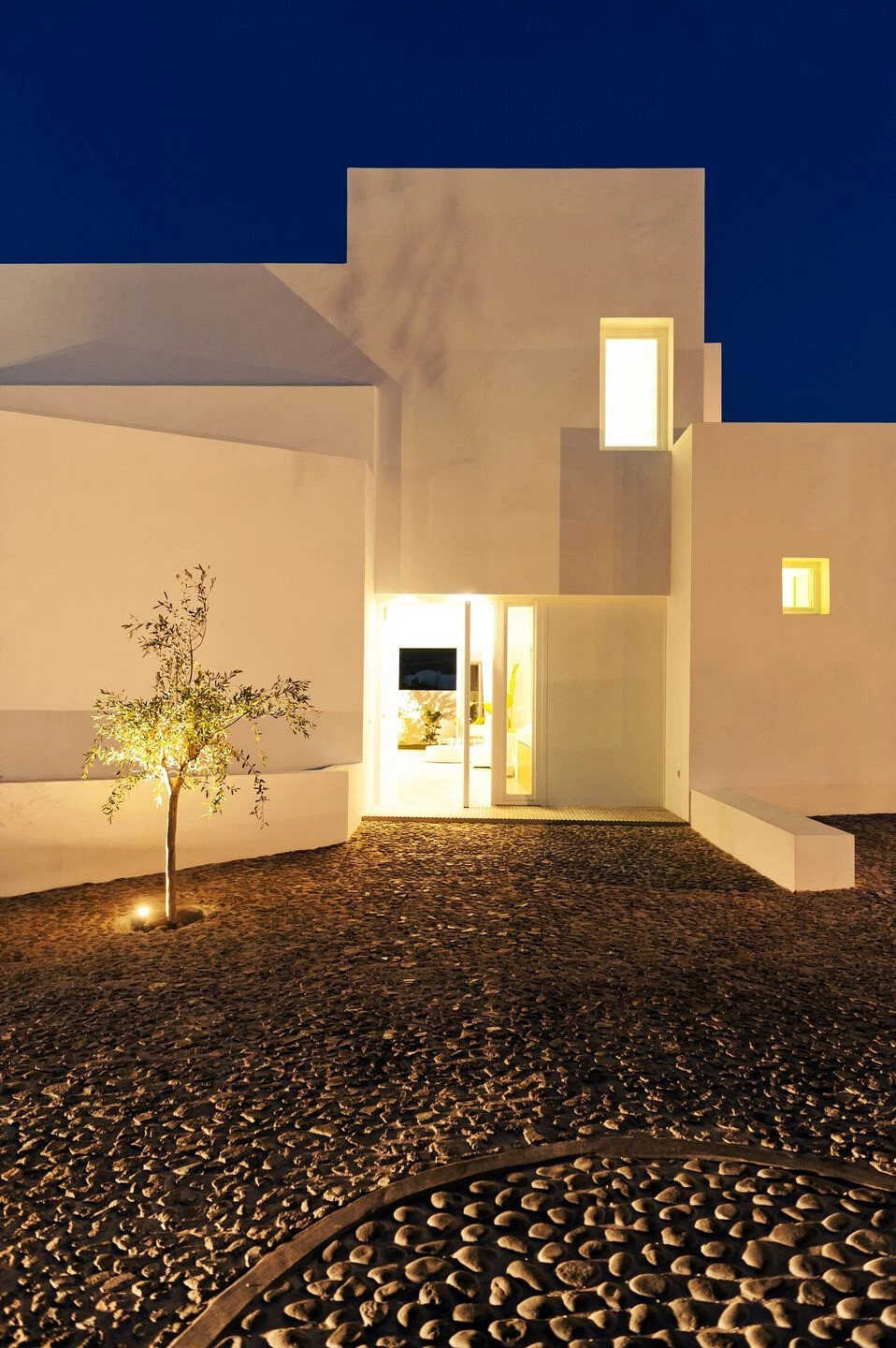 A striking example of modern Greek island design, this Santorini summer house by Kapsimalis Architects reinterprets traditional cubist architecture with clean lines, open volumes, and a serene palette of white and grey.