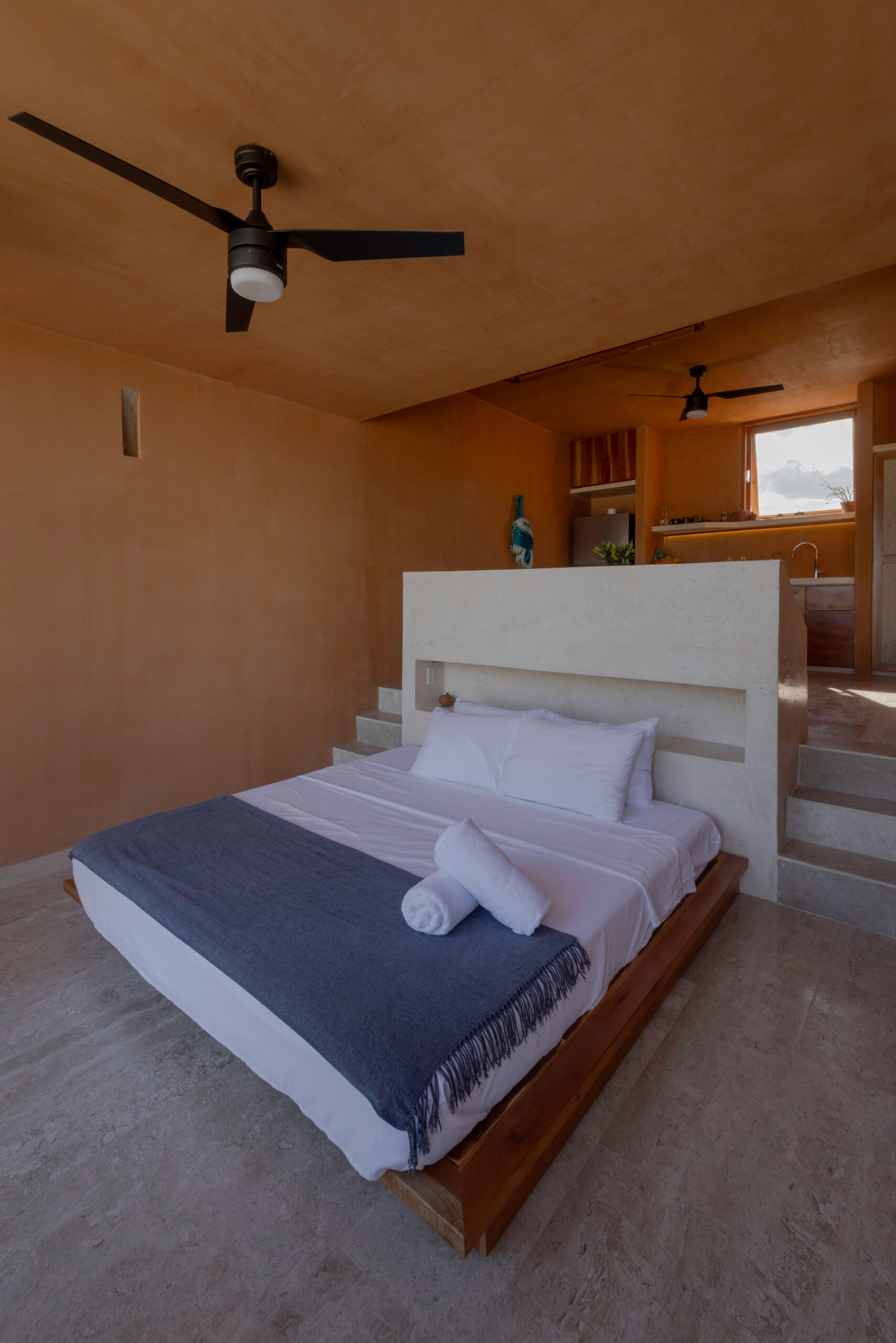 Upstairs, a large window and balcony frame the sea, with interiors designed to stay cool while capturing ocean breezes.