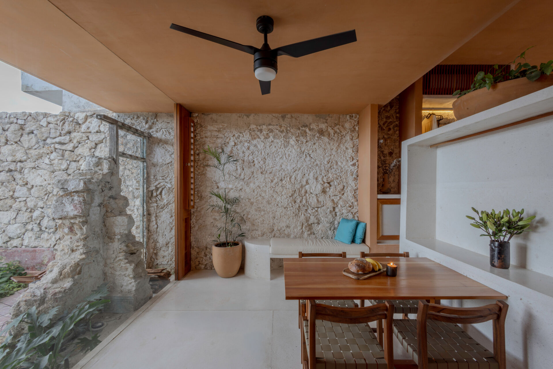 The lower unit features a garden, open kitchen, dining area, bedroom, and bathroom, designed to feel airy and connected through two sunlit courtyards.