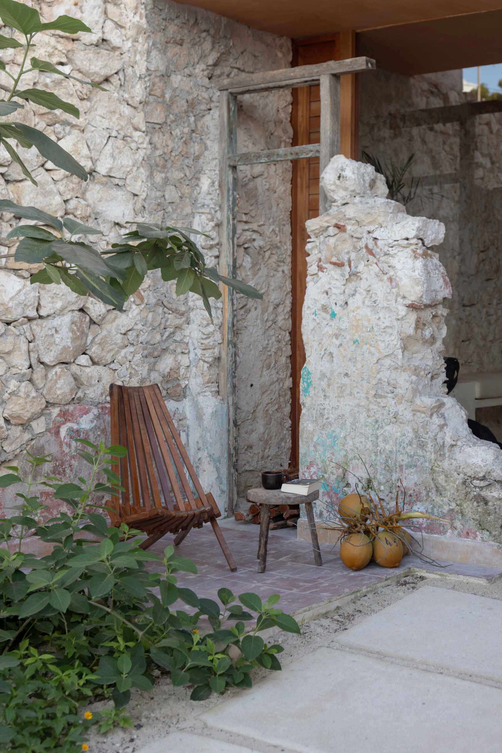 The lower unit features a garden, open kitchen, dining area, bedroom, and bathroom, designed to feel airy and connected through two sunlit courtyards.