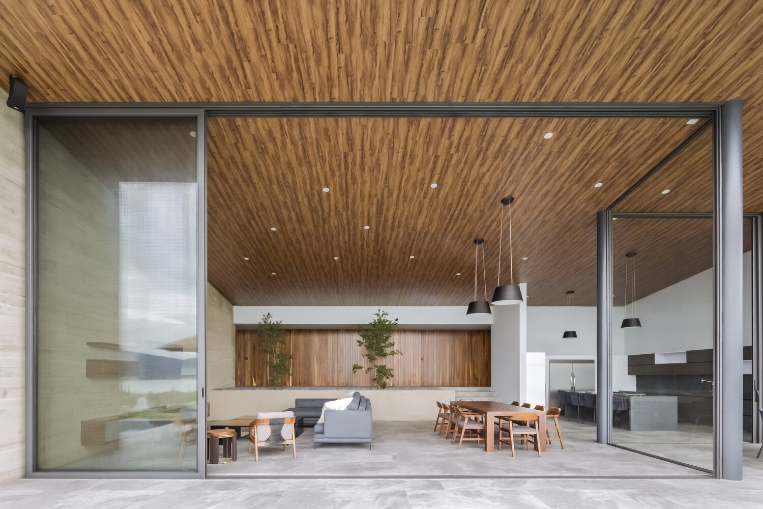 Sliding glass walls open to a pool, firepit, and shaded lounge, turning every day into lakeside living.