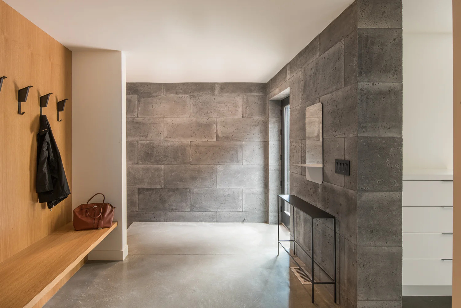 A glass front door welcomes you to the home and once inside there’s a dedicated space for hanging jackets and putting on shoes. A couple of steps lead to the main living area of the house.