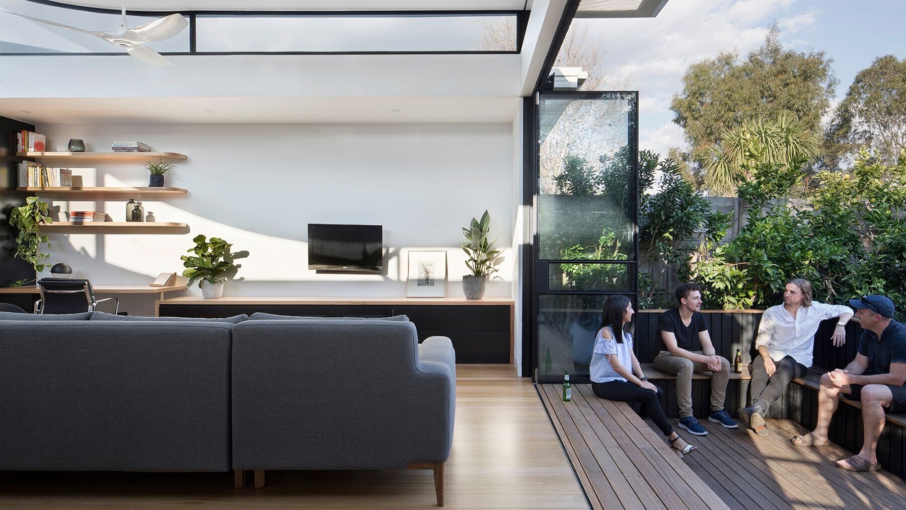 This terrace house opens to the backyard with a timber deck, built-in seating and glass doors that bring the garden directly into daily life.