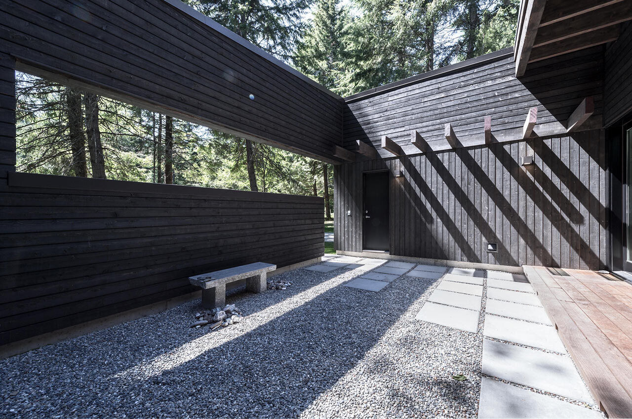 A private courtyard acts as a serene transition from forest to home, beautifully designed to balance light and keep wandering elk at bay.