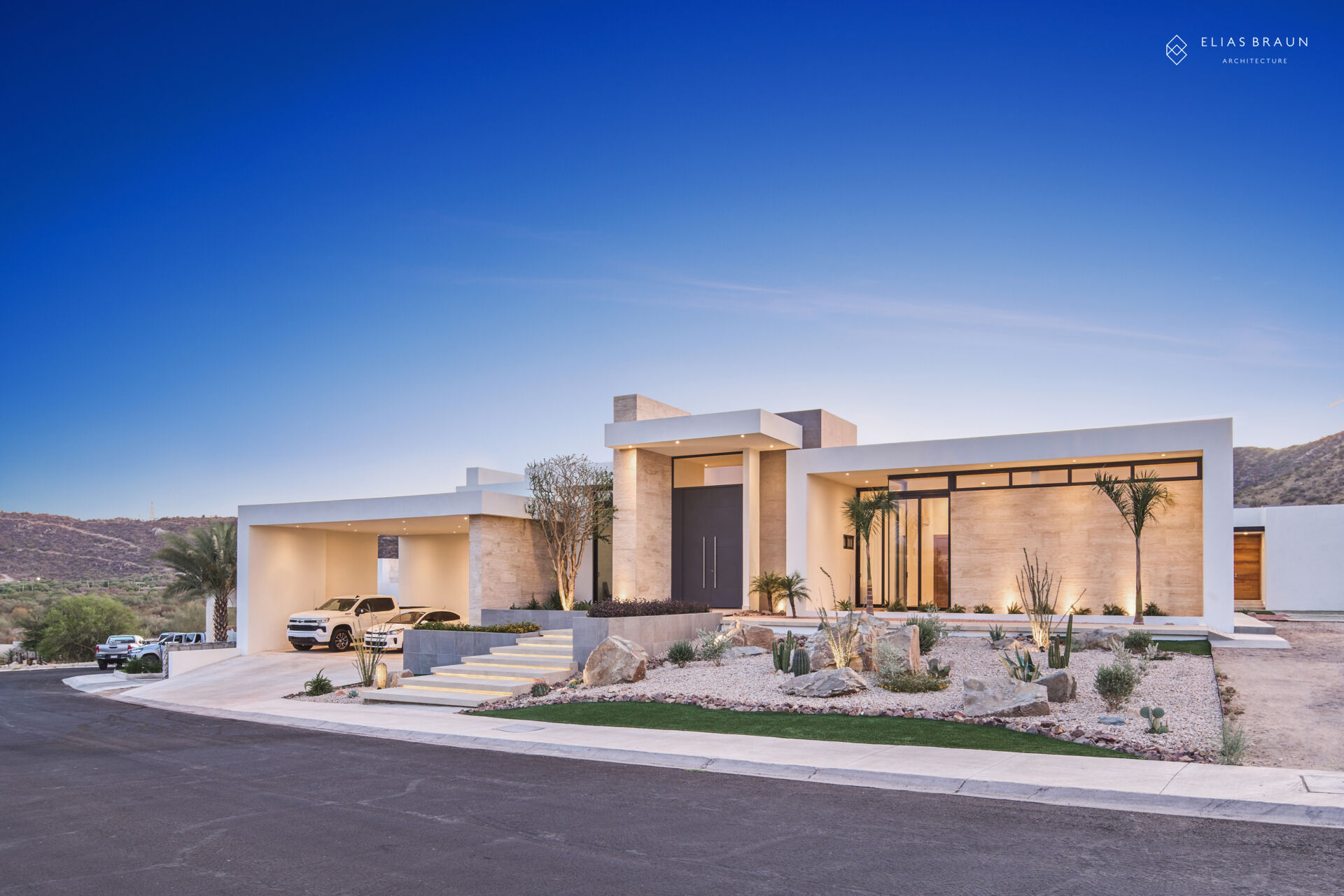 A contemporary desert home in Hermosillo, Sonora, where architecture meets precision and calm. The striking five-meter steel door opens to a light-filled interior that frames the natural reserve beyond. Every level, line, and shadow is tuned to the desert’s rhythm, creating a sense of arrival that feels both sculptural and serene.