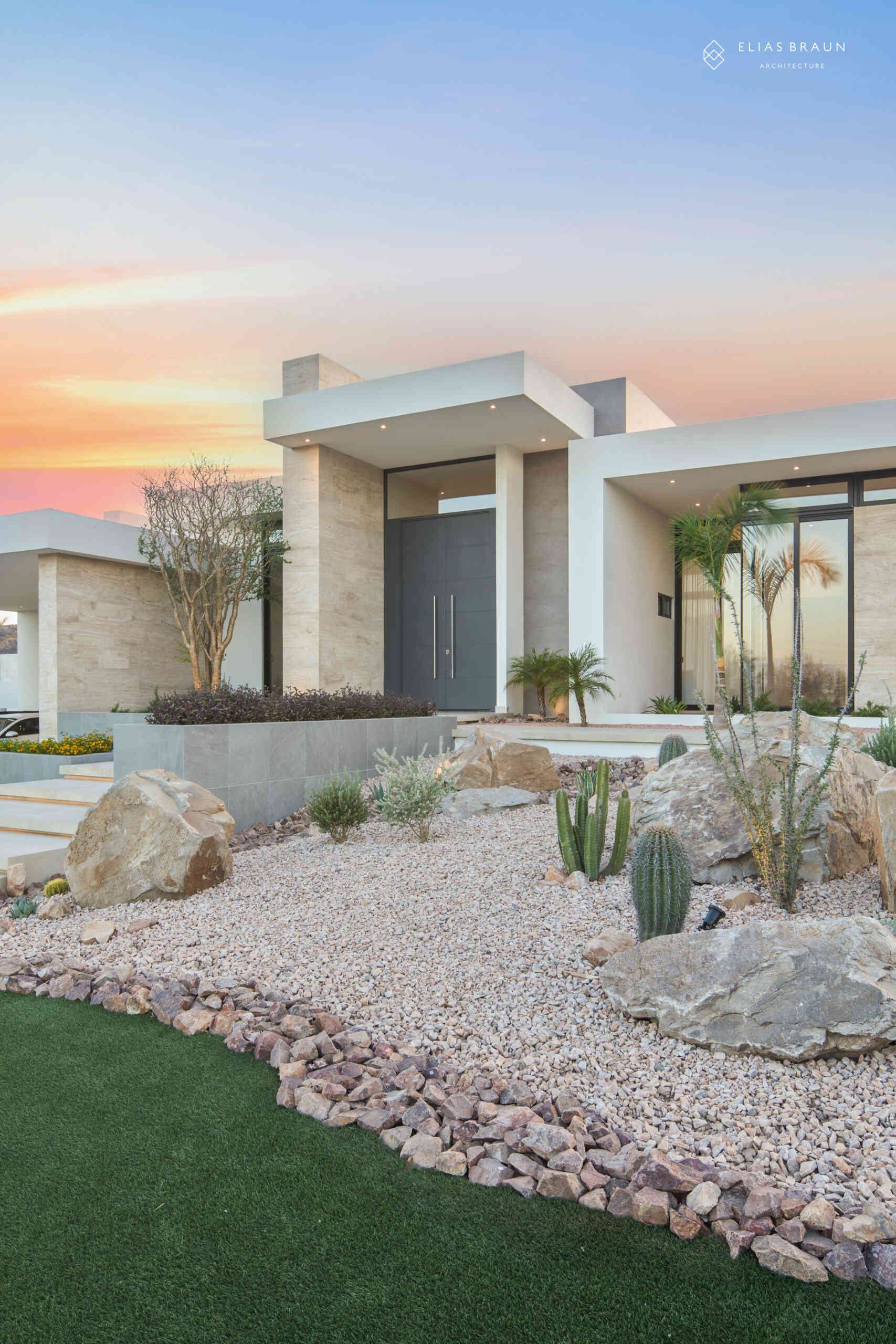 A contemporary desert home in Hermosillo, Sonora, where architecture meets precision and calm. The striking five-meter steel door opens to a light-filled interior that frames the natural reserve beyond. Every level, line, and shadow is tuned to the desert’s rhythm, creating a sense of arrival that feels both sculptural and serene.