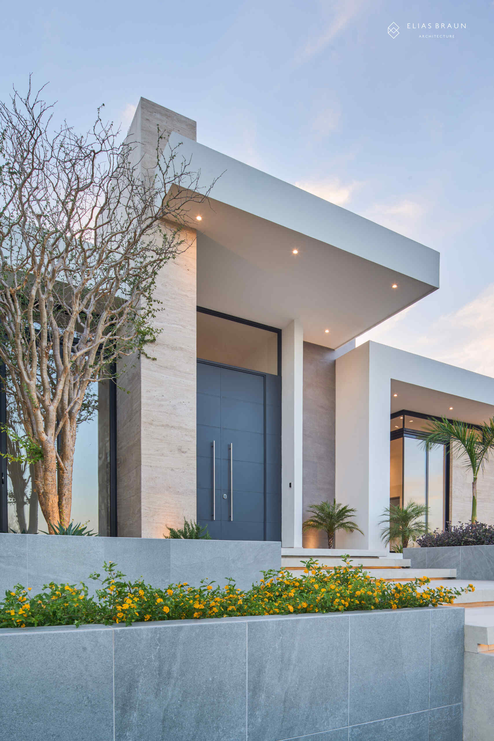 A contemporary desert home in Hermosillo, Sonora, where architecture meets precision and calm. The striking five-meter steel door opens to a light-filled interior that frames the natural reserve beyond. Every level, line, and shadow is tuned to the desert’s rhythm, creating a sense of arrival that feels both sculptural and serene.