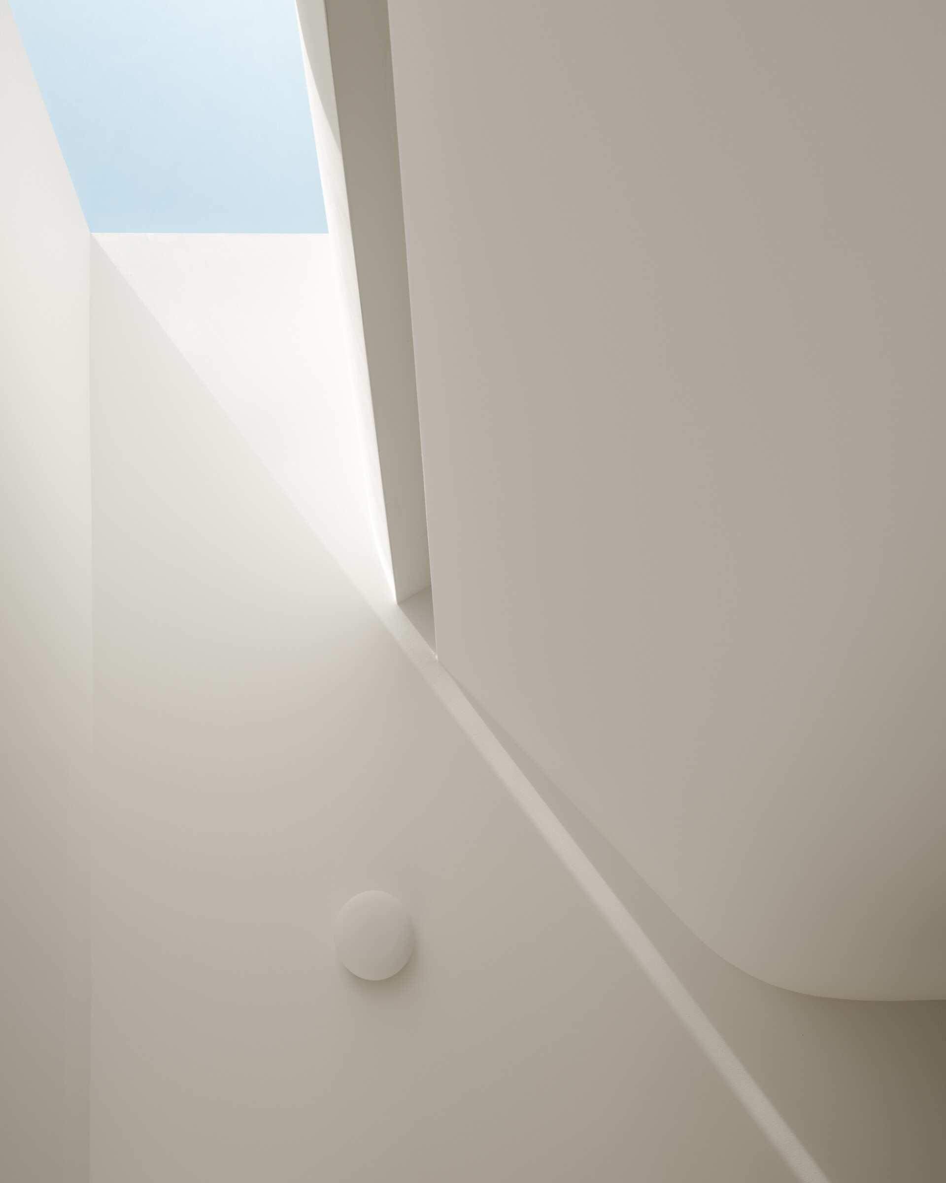 At the heart of the home, a central skylit stairwell channels sunlight and functions as a passive ventilation chimney.