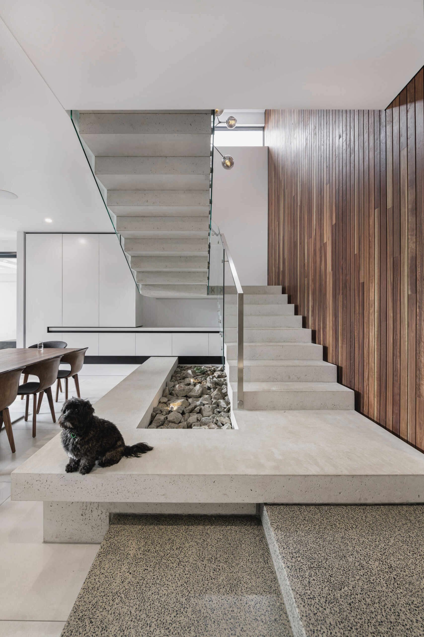 At the center of the home, a floating white concrete stair becomes a sculptural anchor. It captures the paradox that defines the house: heavy yet light, solid yet fluid. Its presence reinforces the craftsmanship at play, a feat that required both technical precision and artistic restraint.