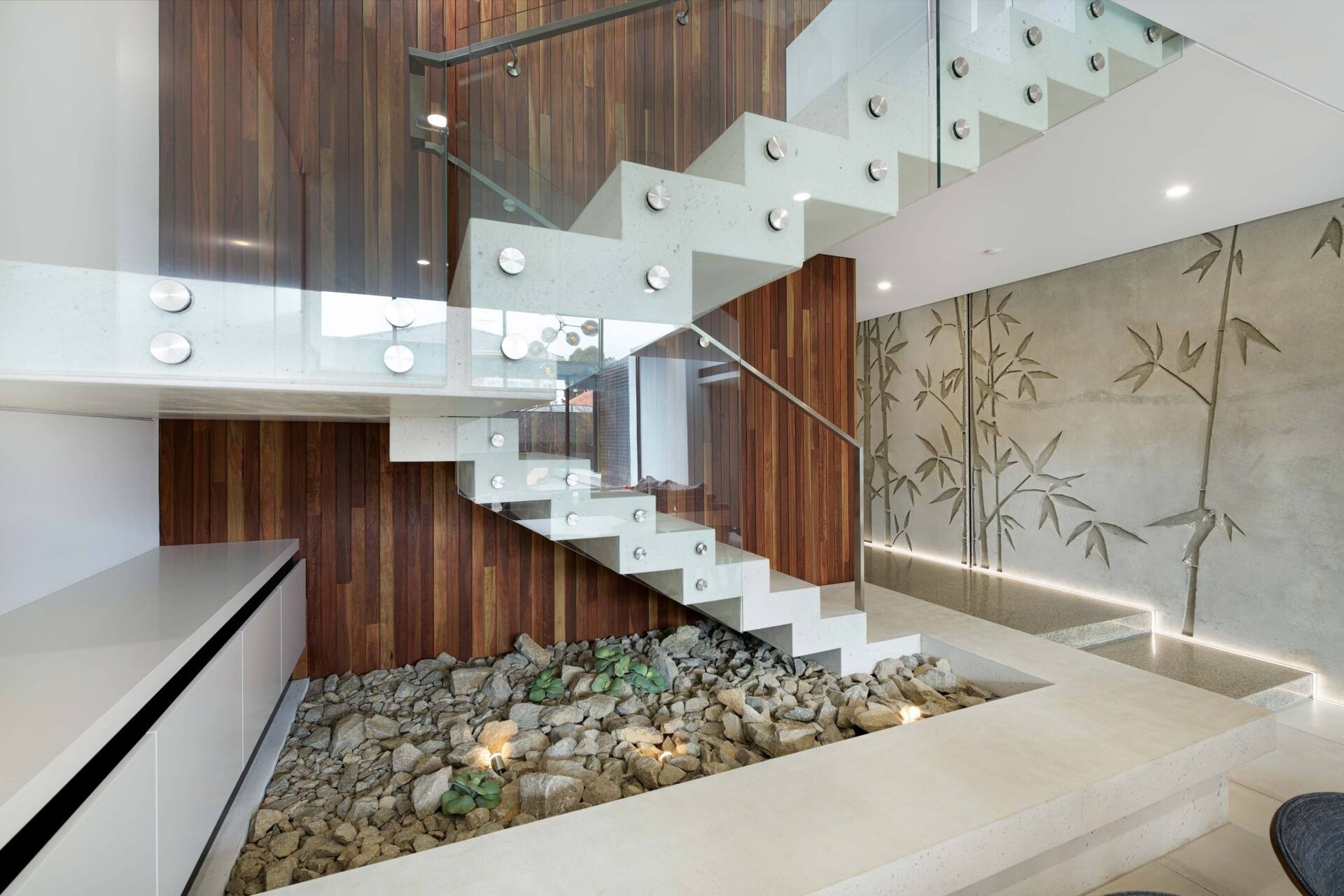 At the center of the home, a floating white concrete stair becomes a sculptural anchor. It captures the paradox that defines the house: heavy yet light, solid yet fluid. Its presence reinforces the craftsmanship at play, a feat that required both technical precision and artistic restraint.