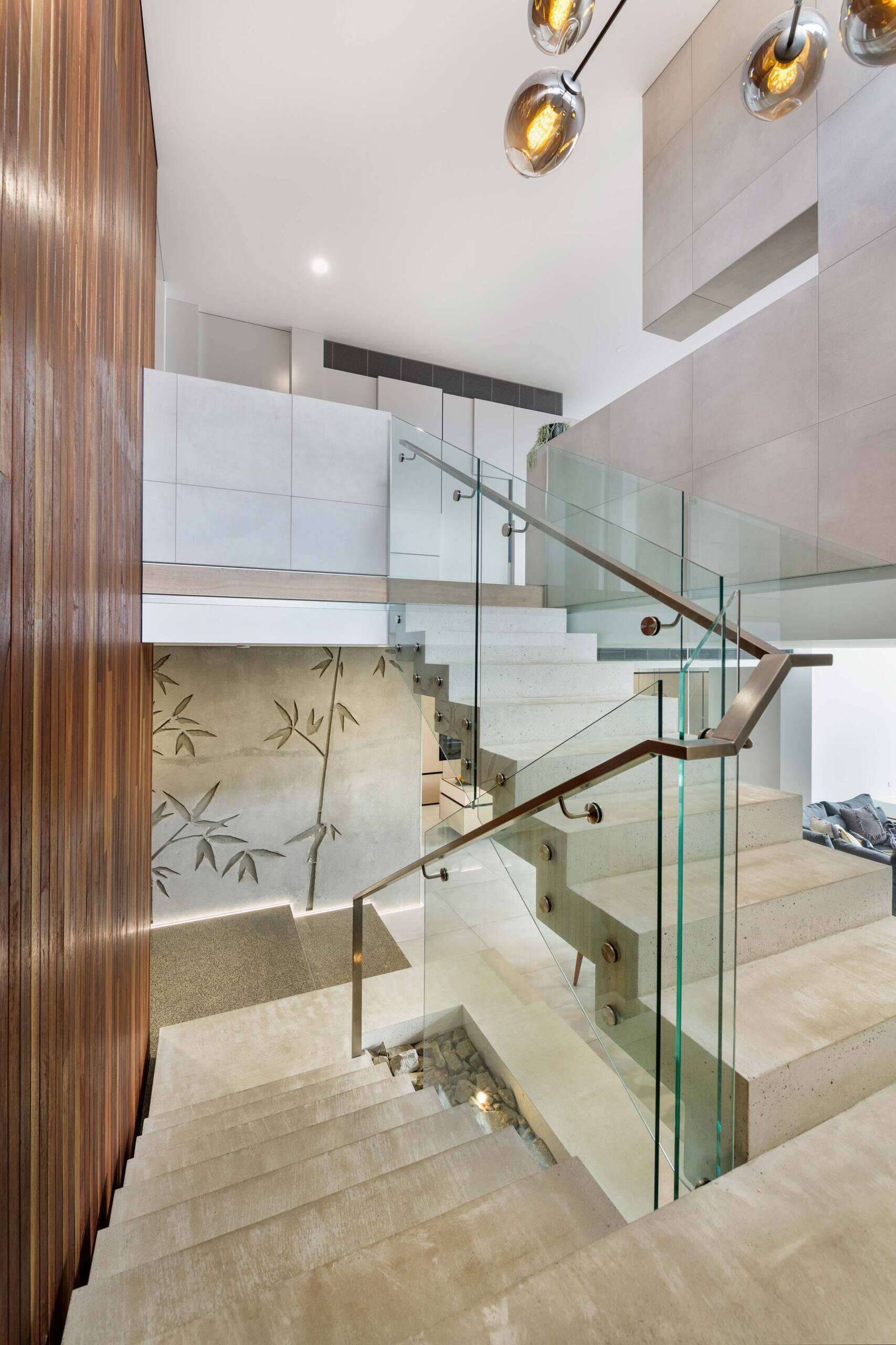 At the center of the home, a floating white concrete stair becomes a sculptural anchor. It captures the paradox that defines the house: heavy yet light, solid yet fluid. Its presence reinforces the craftsmanship at play, a feat that required both technical precision and artistic restraint.