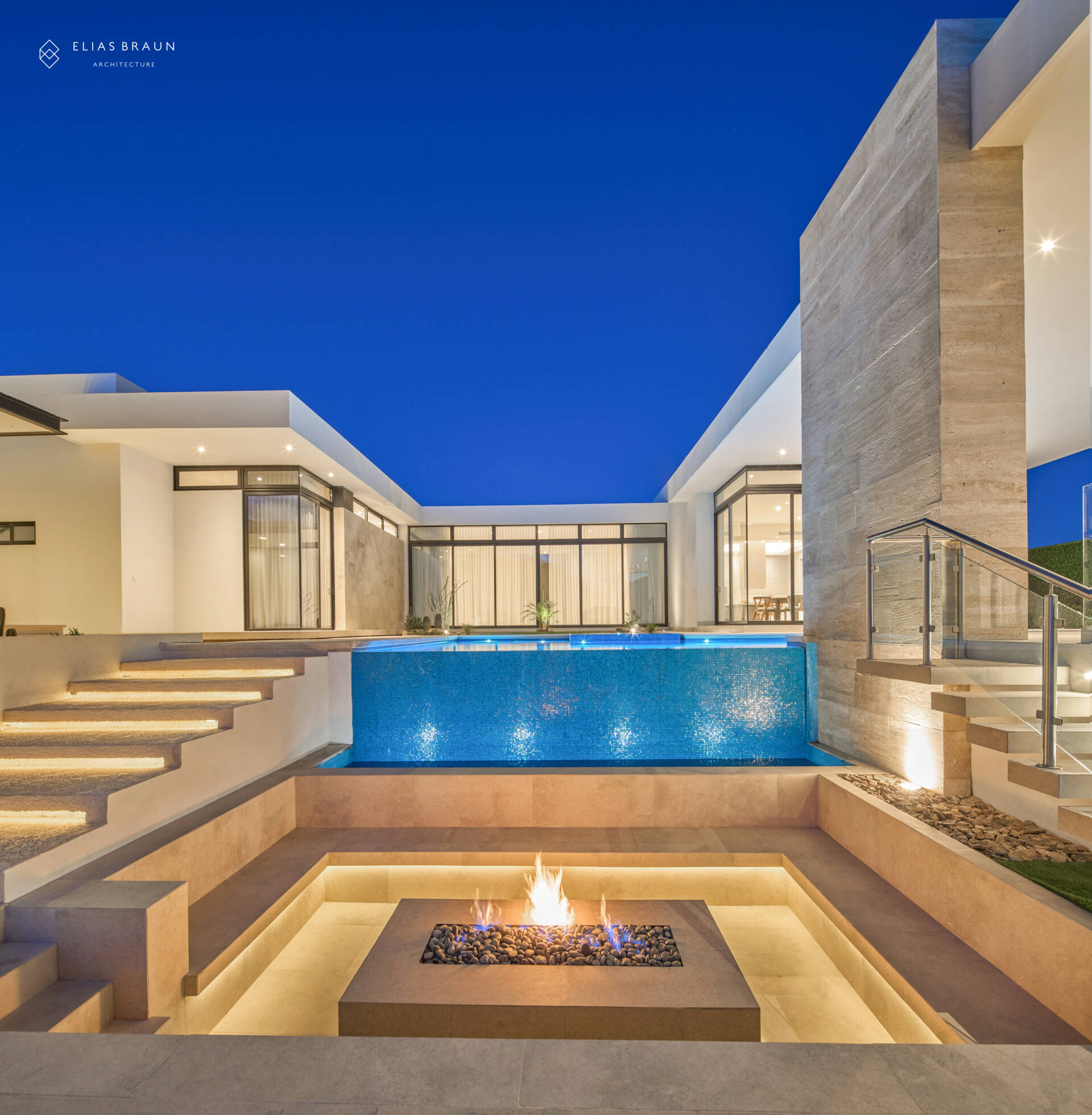 At the lowest terrace of this desert home, the fire pit becomes the gathering point when the air cools. Surrounded by travertine, glass, and desert views, it anchors evenings of quiet conversation under Sonora’s vast sky, bringing warmth to the home’s restrained, timeless palette.