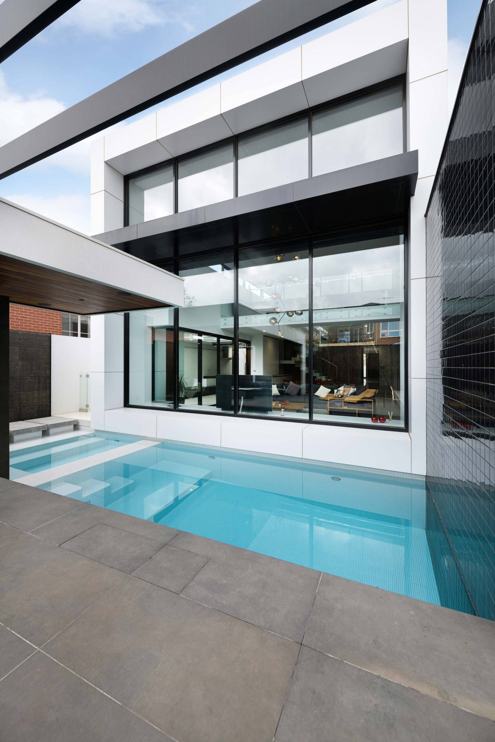Reflections from the pool dance across the concrete walls, connecting architecture and landscape. A serene outdoor space that extends the home’s calm interior.