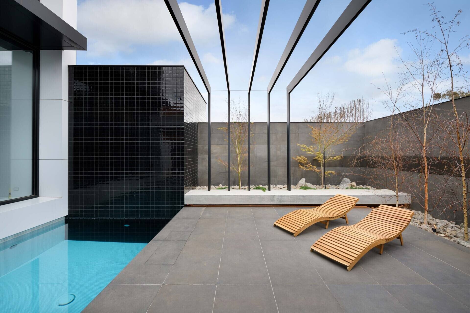 Reflections from the pool dance across the concrete walls, connecting architecture and landscape. A serene outdoor space that extends the home’s calm interior.