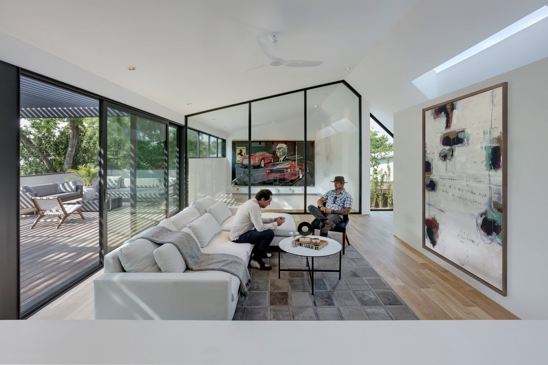 The upper level seems to float above the garage, its black-framed glass wall providing a view of the cars below. The architects used this visual connection to blur the boundary between hobby and home, a perfect reflection of the couple’s intertwined lifestyle.