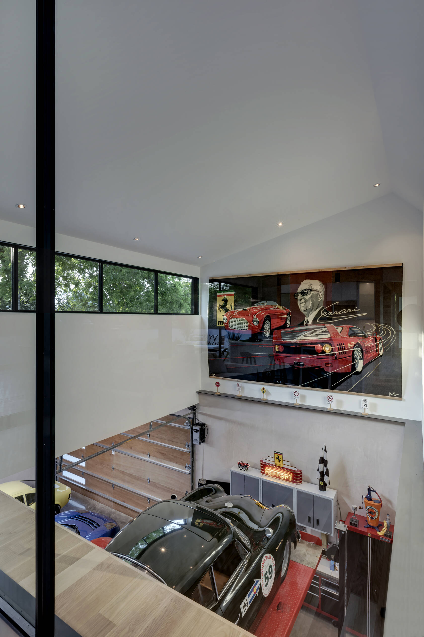 The upper level seems to float above the garage, its black-framed glass wall providing a view of the cars below. The architects used this visual connection to blur the boundary between hobby and home, a perfect reflection of the couple’s intertwined lifestyle.