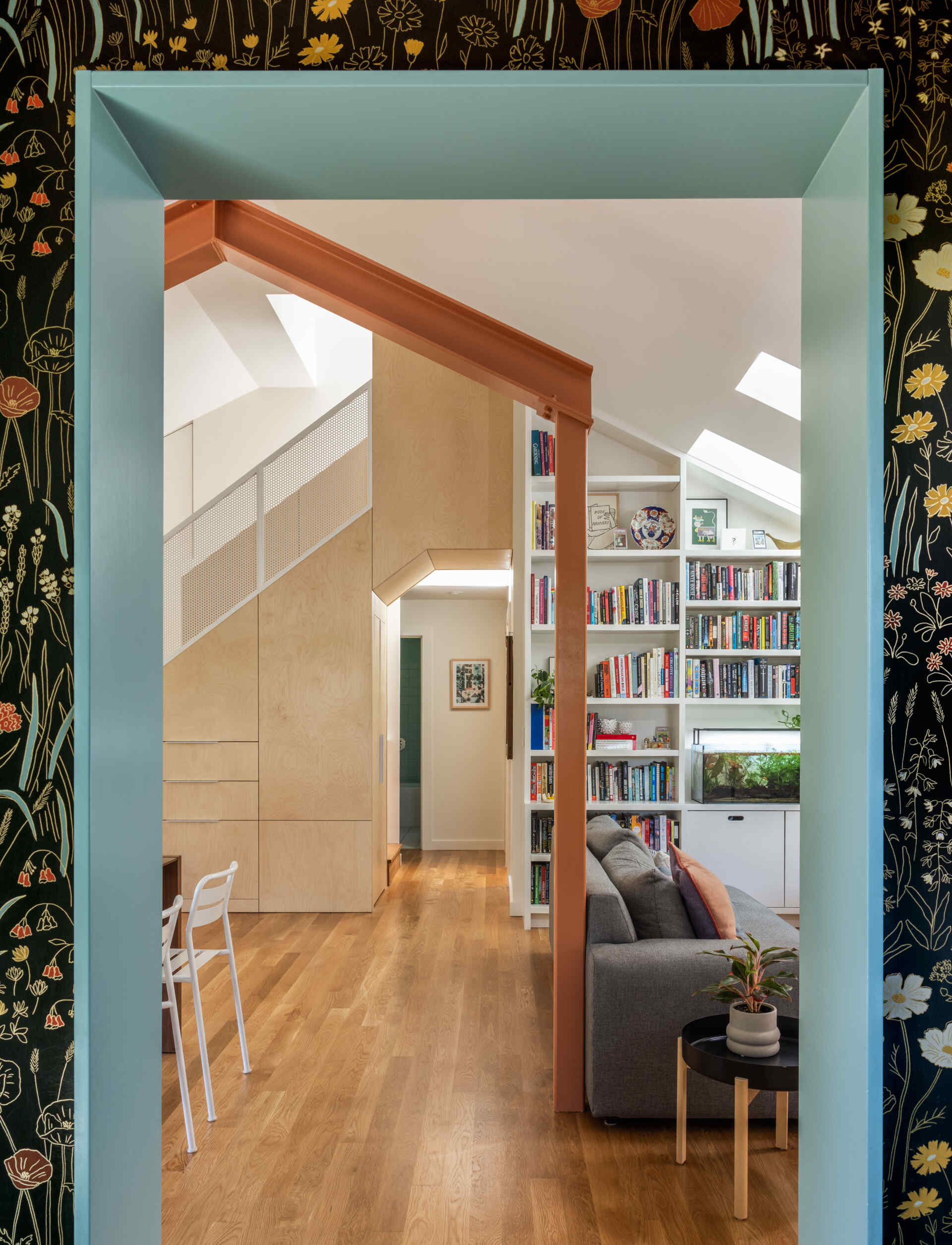 The striking plywood and perforated metal stair leads to a serene new primary suite.