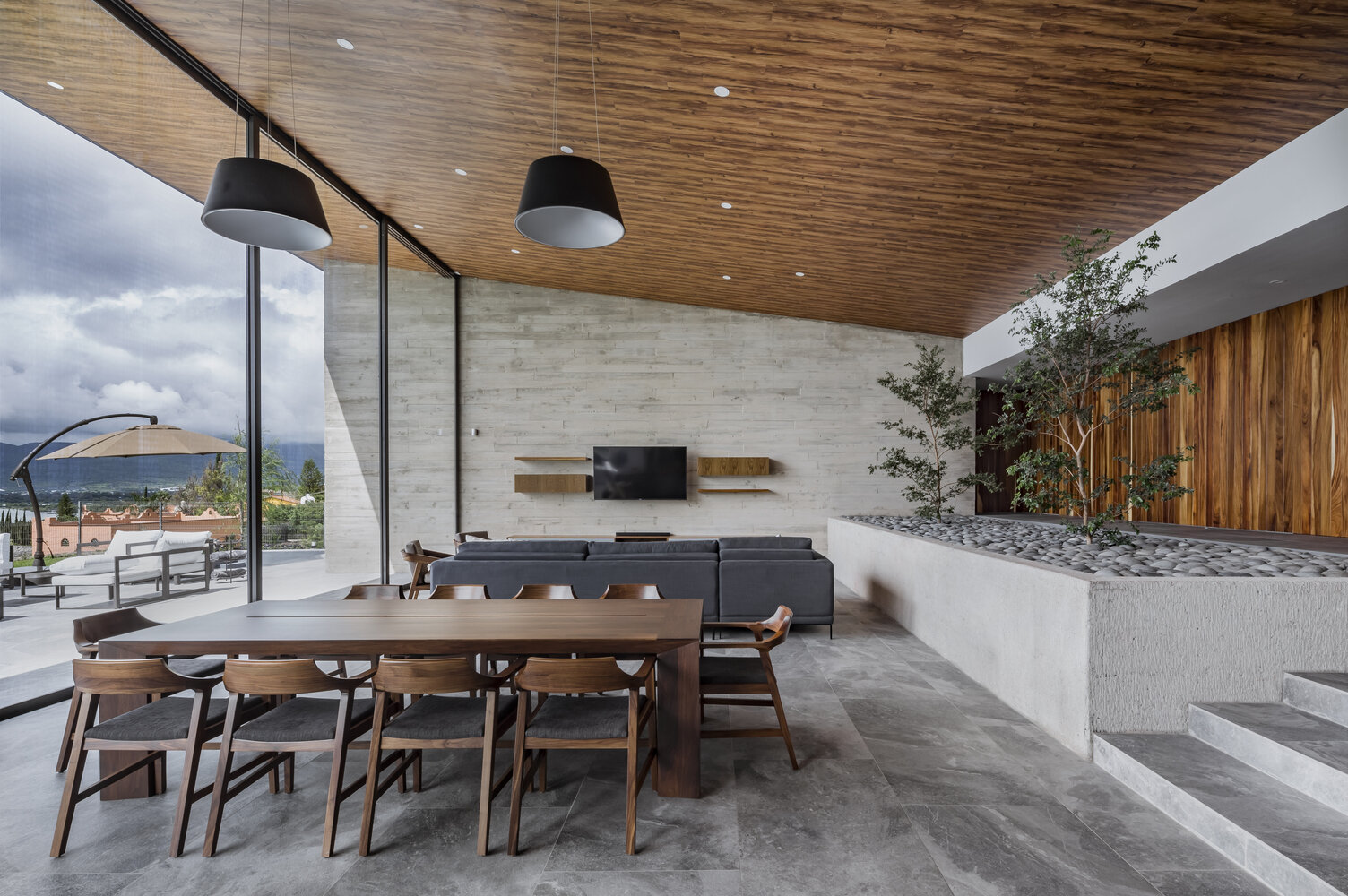 Sliding glass walls open to a pool, firepit, and shaded lounge, turning every day into lakeside living.