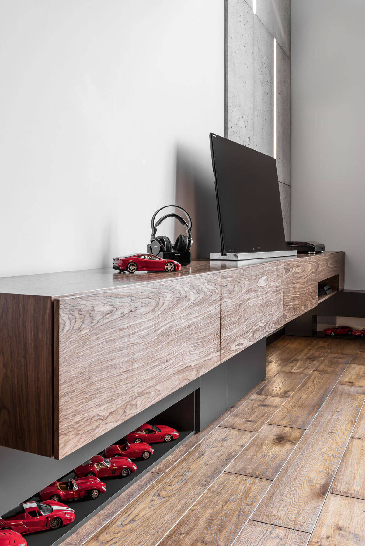 The living room features a concrete accent wall with embedded lighting and a custom wood console, blending warmth and minimalism in this modern apartment interior.