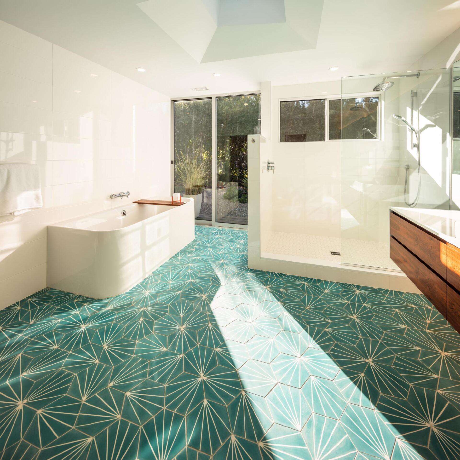Thisi mid-century modern inspired bathroom surprises with a burst of color on the tiled floor. Against a mostly white backdrop, it becomes an energizing detail in an otherwise serene space.