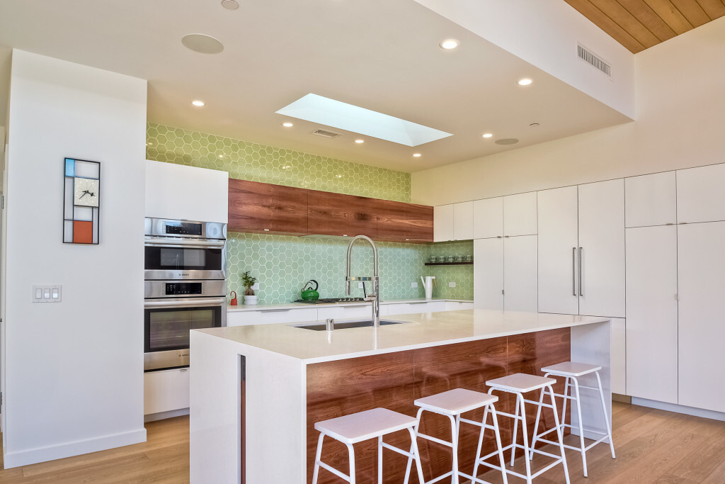 Light green hex tiles and a white-and-wood palette keep the kitchen bright and fresh.
