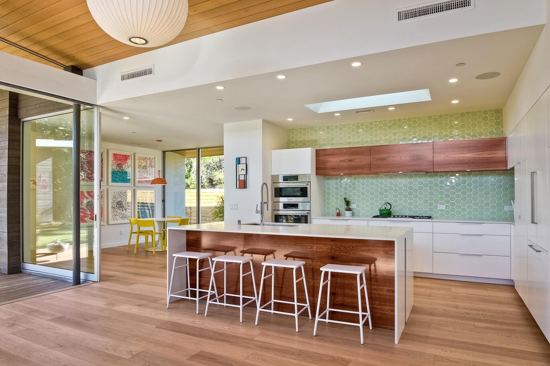 Light green hex tiles and a white-and-wood palette keep the kitchen bright and fresh.