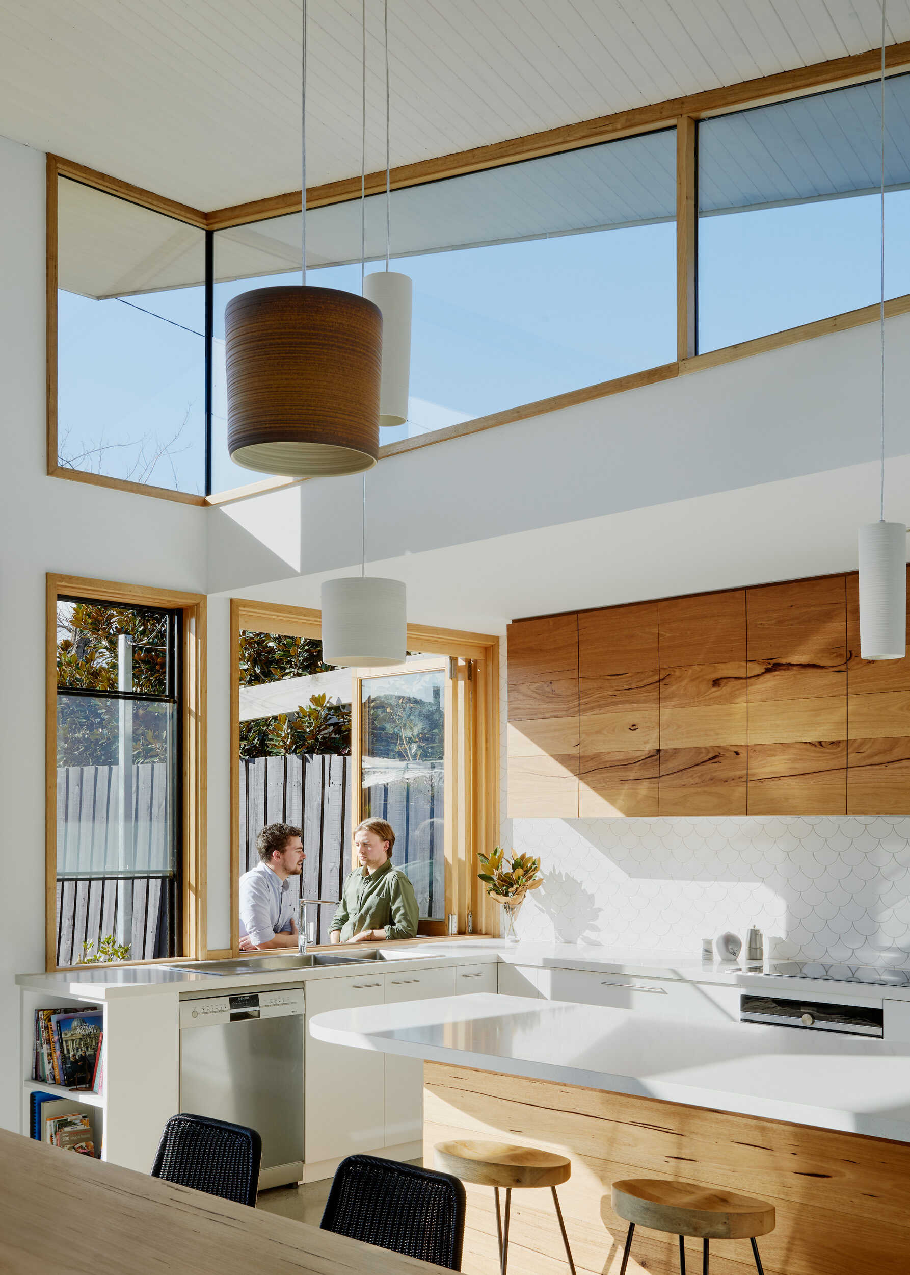 A kitchen window opens to a recycled brick patio, turning into a bar for easy outdoor entertaining, the essence of Australian indoor-outdoor living.