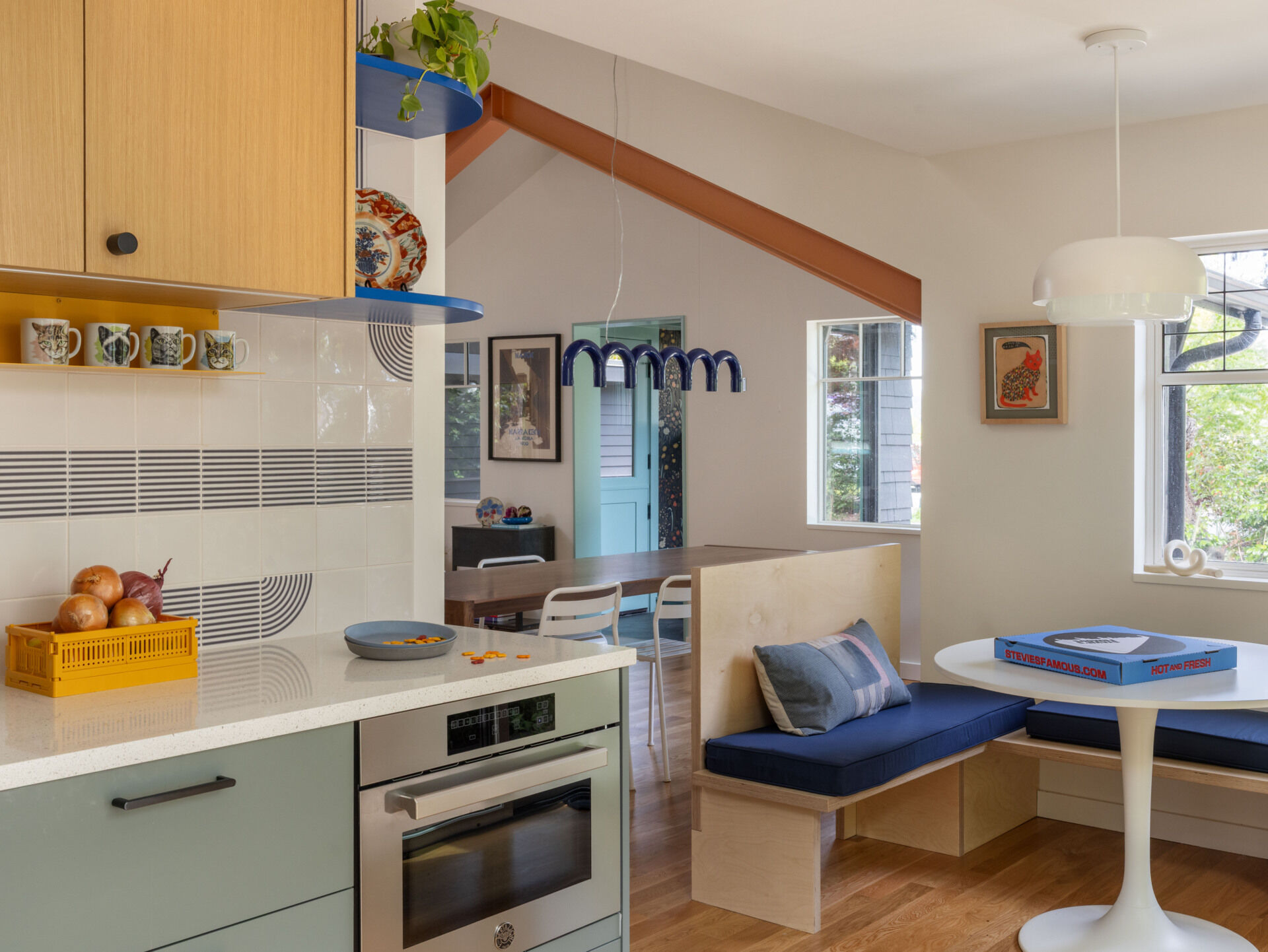 BEFORE - The updated kitchen flows into the dining nook with fresh cabinetry, tile, and appliances.