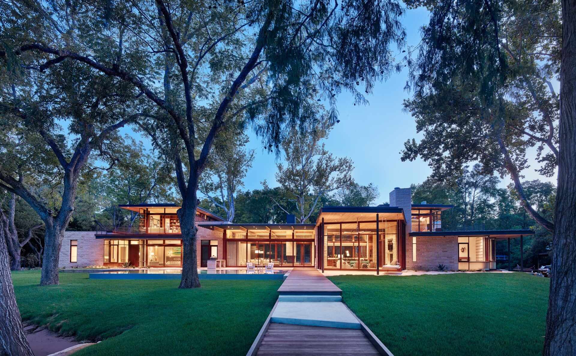 This Lake Austin home by A Parallel Architecture is a masterclass in lakeside modernism, blending limestone, wood, and glass in a form that seems to float above the water.