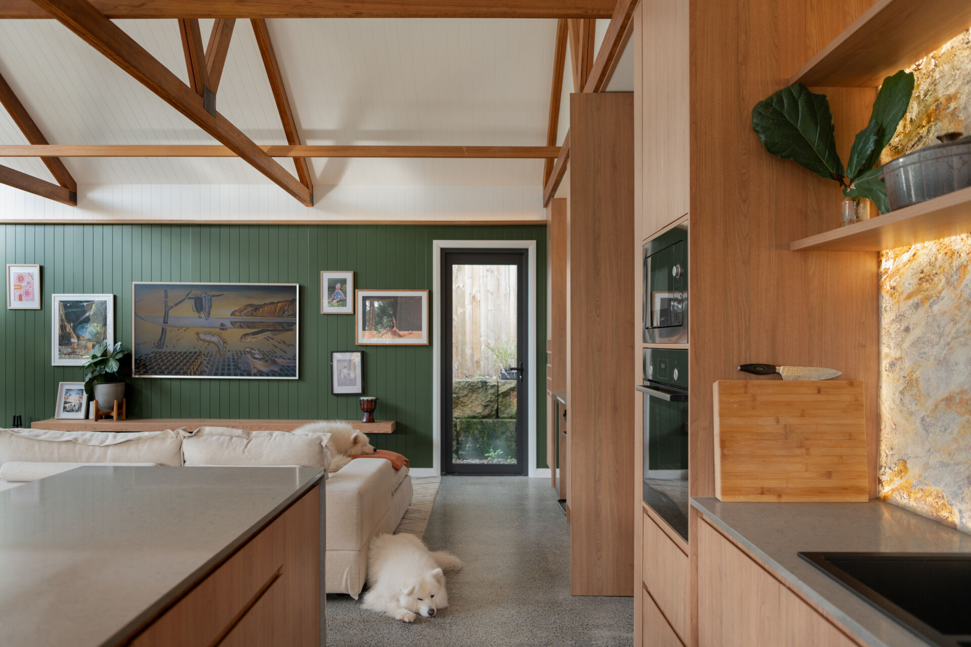 Refined and understated, the kitchen balances practicality with design clarity. A downdraft exhaust keeps sightlines clean, while a luminous splashback adds a hint of playful glow.