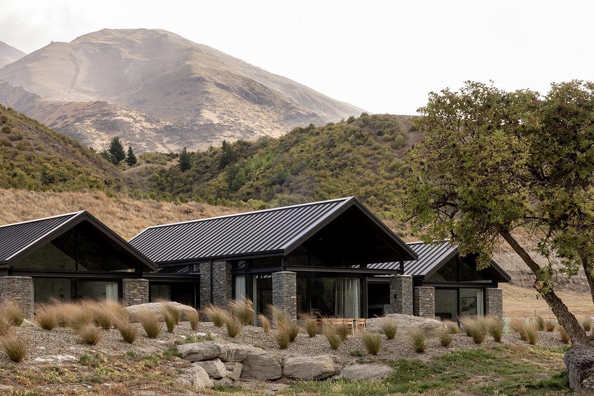 A schist-clad modern home in New Zealand, blends modern design with echoes of historic gold-mining cottages.