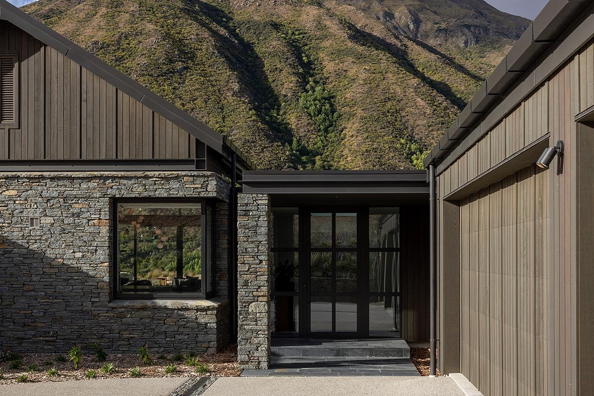 A schist-clad modern home in New Zealand, blends modern design with echoes of historic gold-mining cottages.