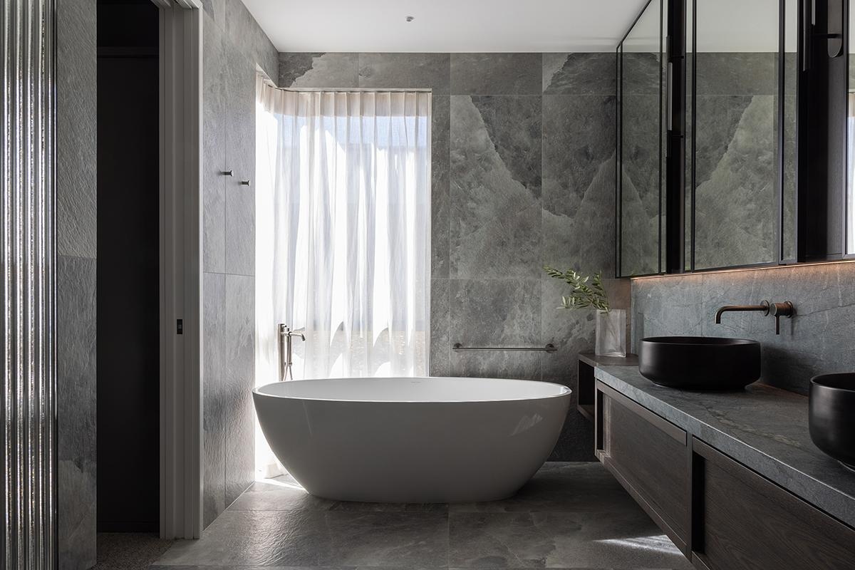 This bathroom continues the theme of understated refinement, where function and atmosphere meet. Every element, from the large format tiles and the floating vanity, to the freestanding bathtub, are designed to create a calming experience that feels aligned with the wider architectural story.