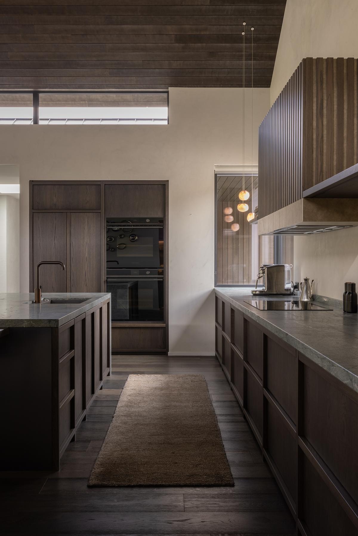 A refined dining area and kitchen by Space Studio, balancing bold architecture with warmth.