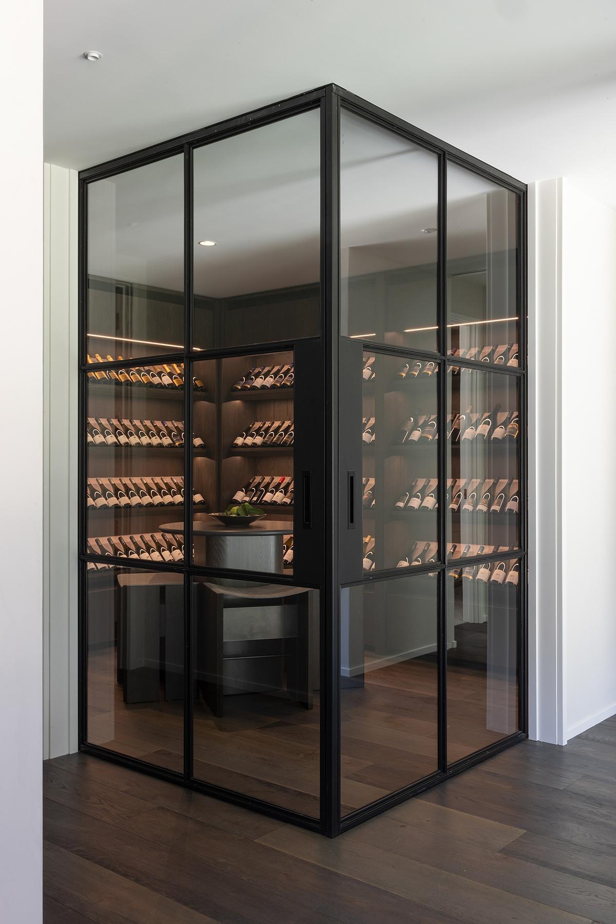 A dedicated wine cellar with glass walls in a modern mountain home in New Zealand.