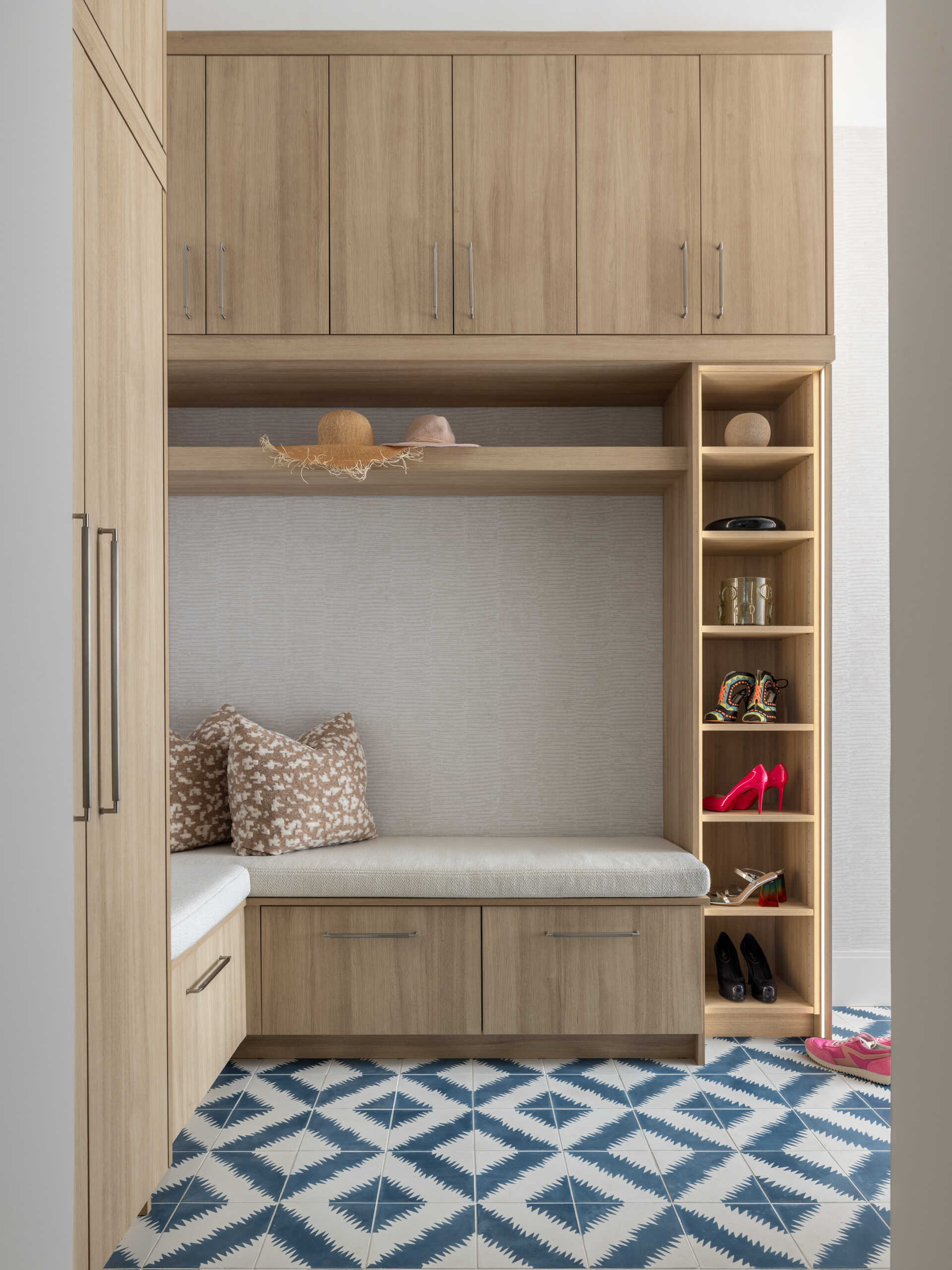 Patterned tile brings a cheerful kick to the laundry. Built-ins keep mess contained in the mudroom. Benches, hooks, and closed storage make coming and going painless. It is the kind of practical luxury that makes a house feel tailored.