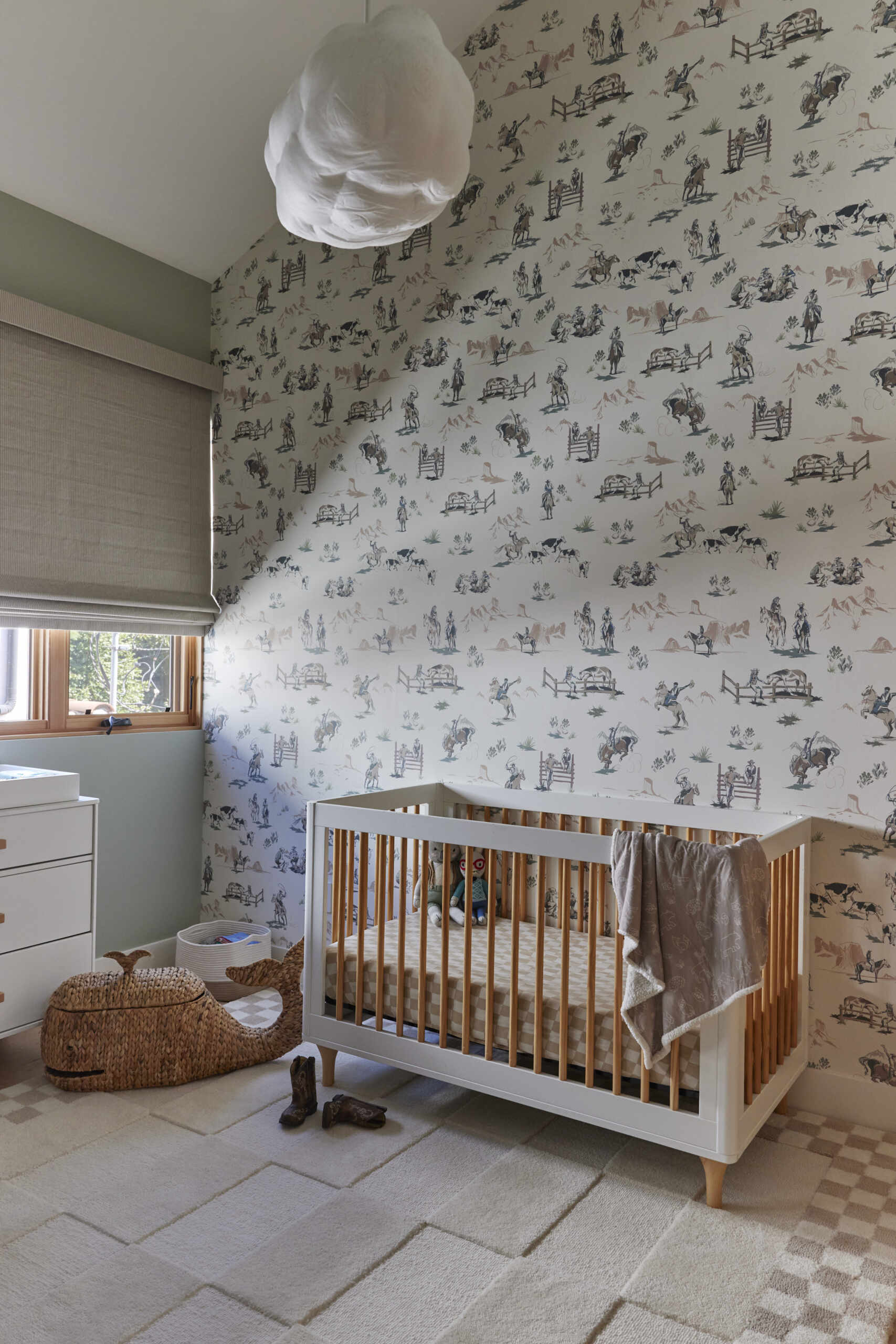 The nursery takes on a vintage cowboy theme with a wallpapered accent wall, creating charm for the youngest family member.