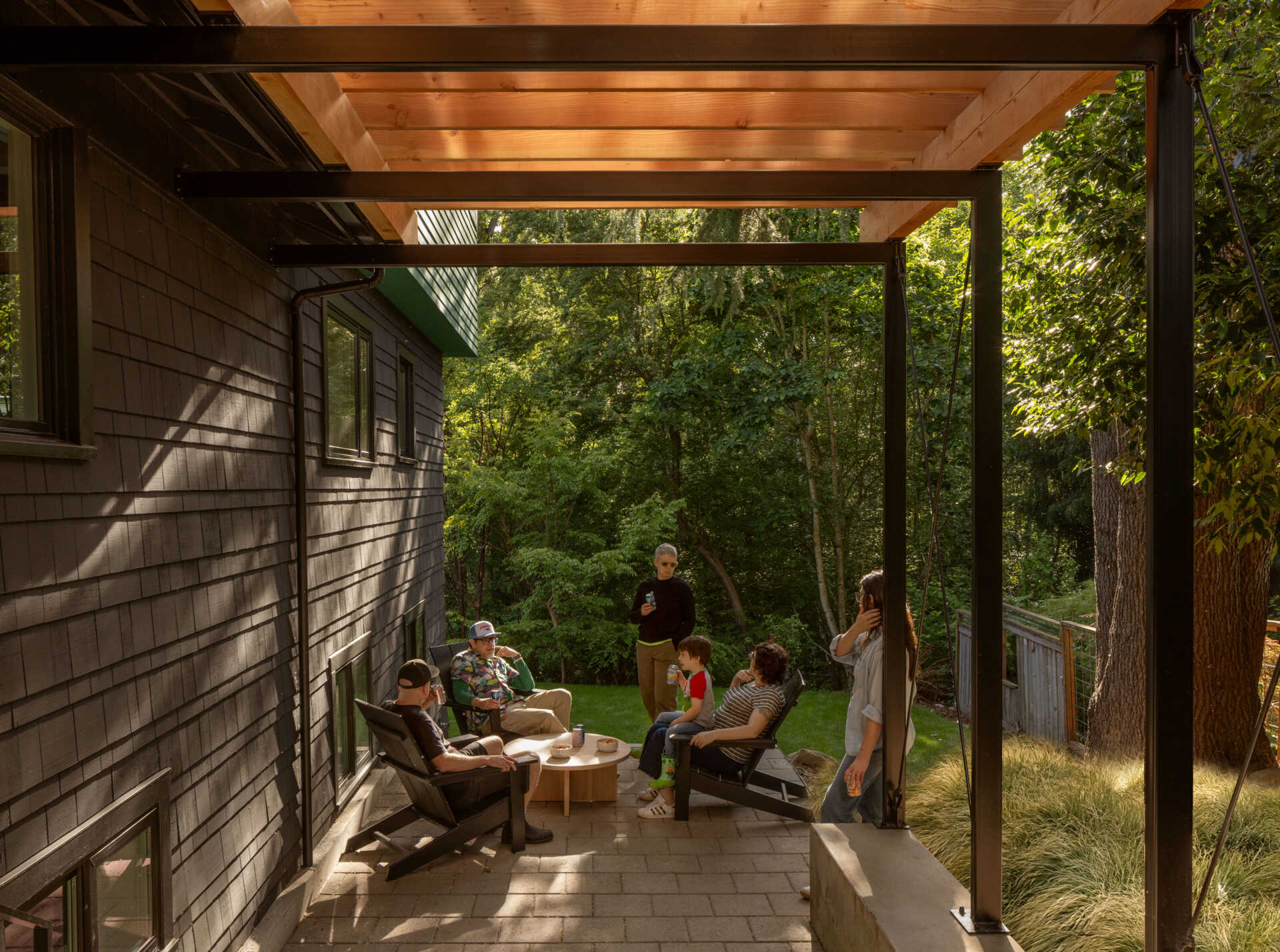 A converted garage now serves as a steel-canopied patio that extends gatherings into the yard.