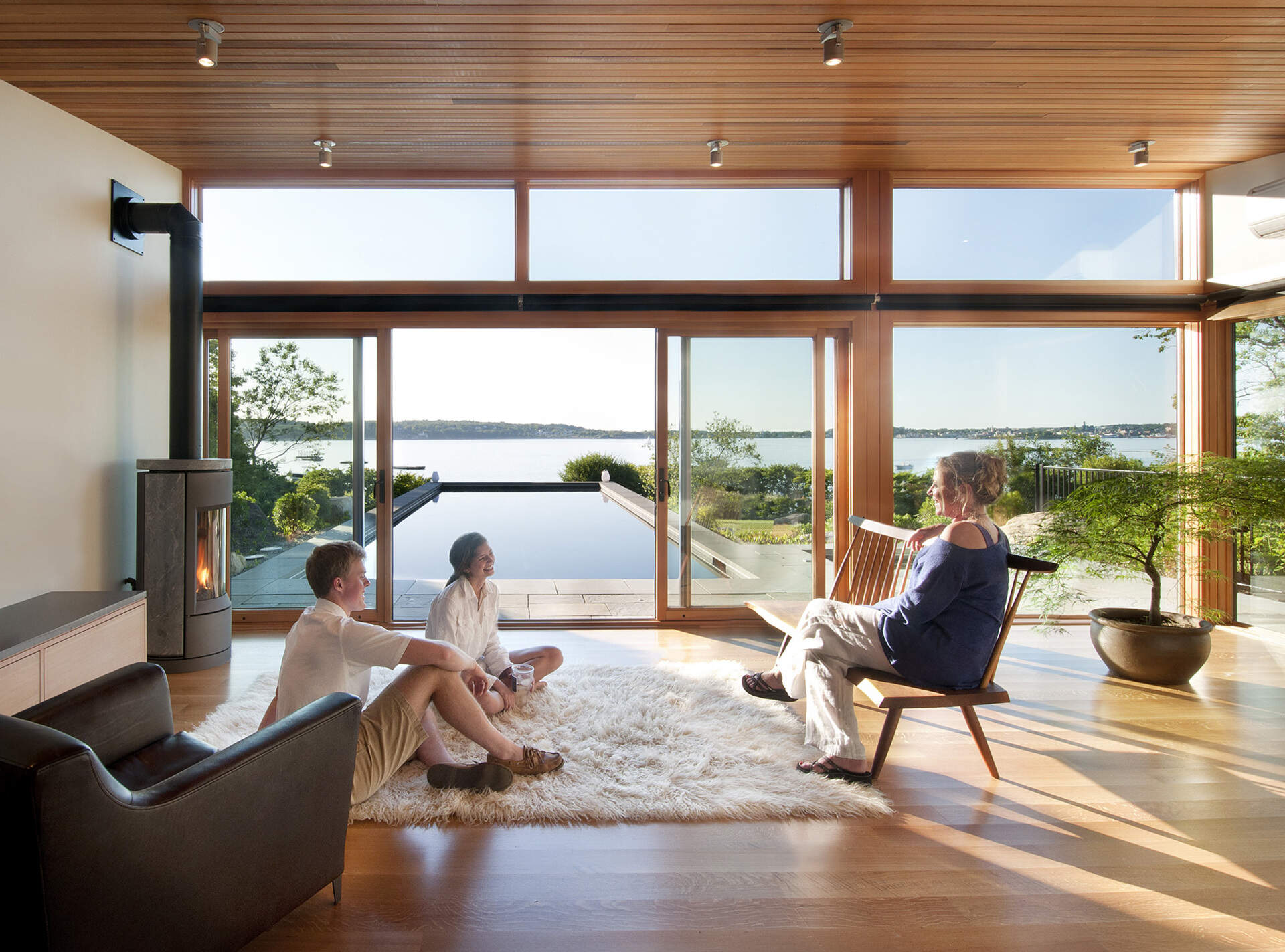 A modern glass-and-wood guest house with a pool and hot tub.
The sloped roof and glass walls frame views of the harbor while inside, yacht-inspired interiors include a custom kitchen, living area, and bath within just 450 square feet.