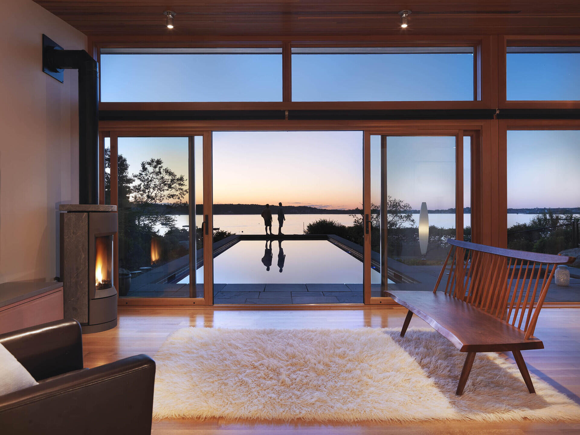 A modern glass-and-wood guest house with a pool and hot tub.
The sloped roof and glass walls frame views of the harbor while inside, yacht-inspired interiors include a custom kitchen, living area, and bath within just 450 square feet.