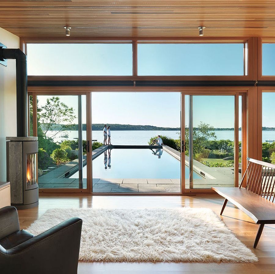 A modern glass-and-wood guest house with a pool and hot tub.
The sloped roof and glass walls frame views of the harbor while inside, yacht-inspired interiors include a custom kitchen, living area, and bath within just 450 square feet.