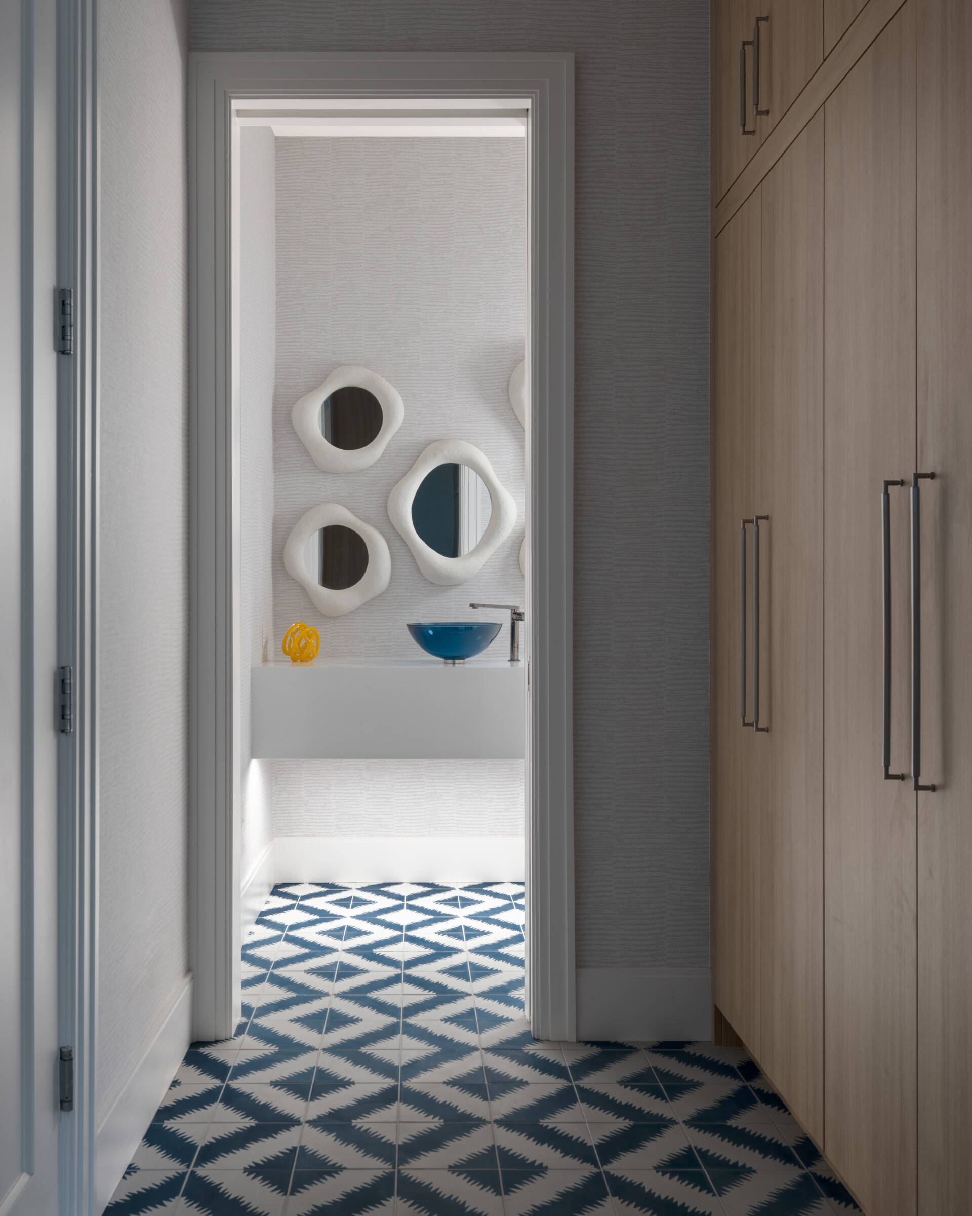 Small room, big mood. Sculptural mirrors, a blue basin, and clever lighting turn the powder room into an unexpected moment. Guests will talk.