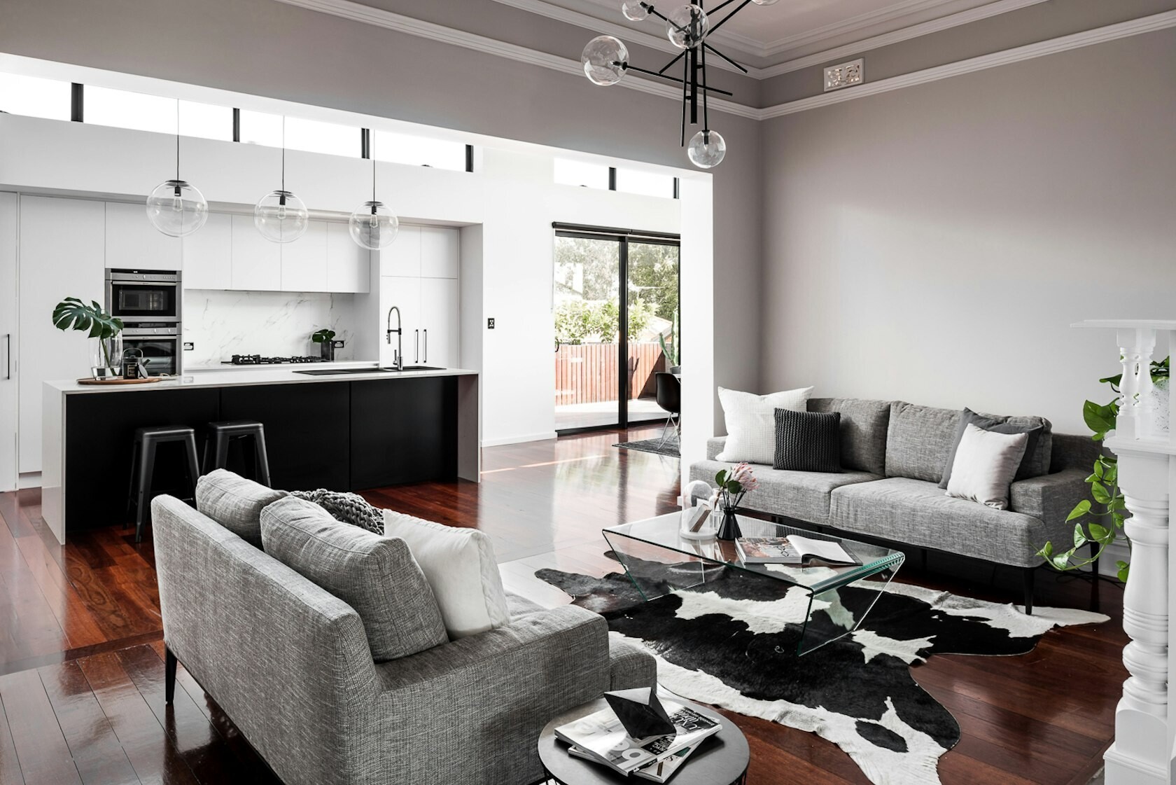 Original details like crown molding and a fireplace bring historic charm to this reimagined living room in a renovated Australian home.