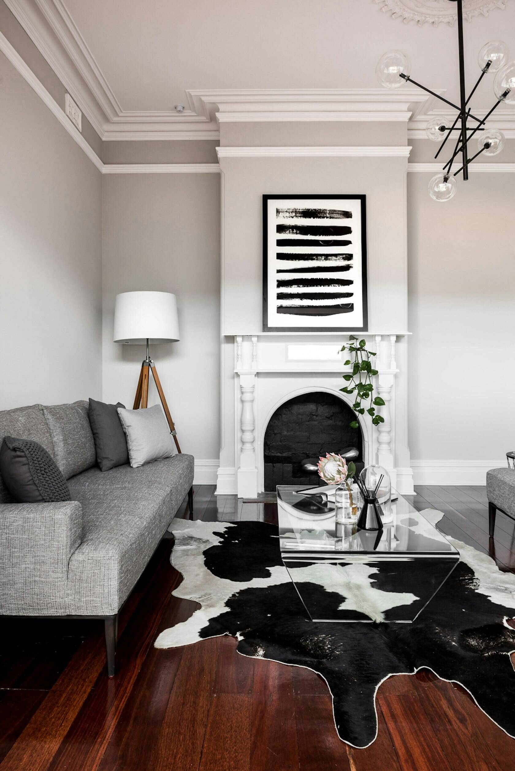 Original details like crown molding and a fireplace bring historic charm to this reimagined living room in a renovated Australian home.
